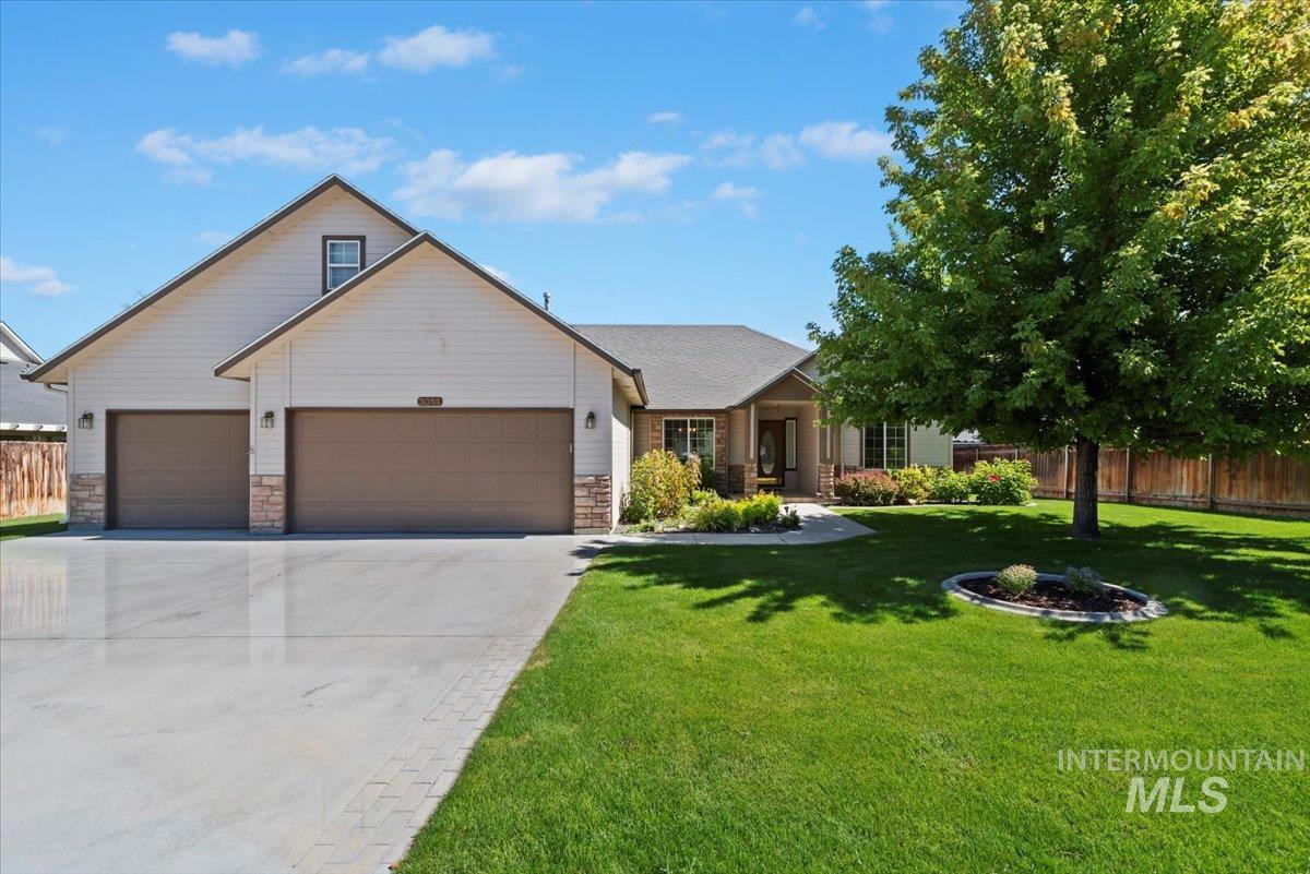 View of front of home featuring concrete driveway, stone siding, and an attached garage