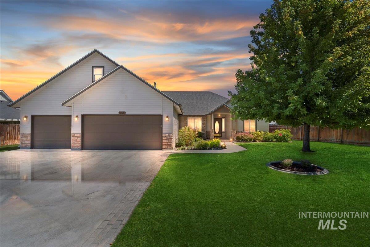 View of front of home with a garage, concrete driveway, and stone siding