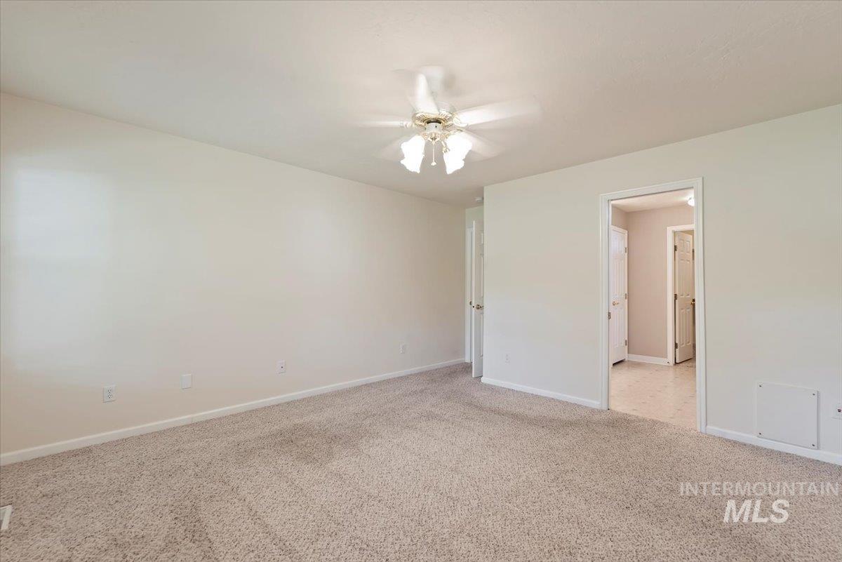 Unfurnished bedroom with light colored carpet and a ceiling fan