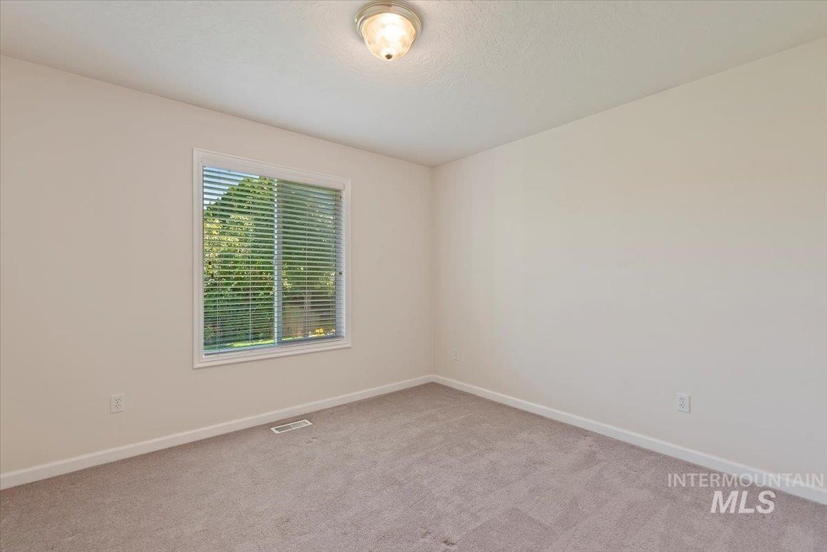 Empty room featuring baseboards and carpet flooring