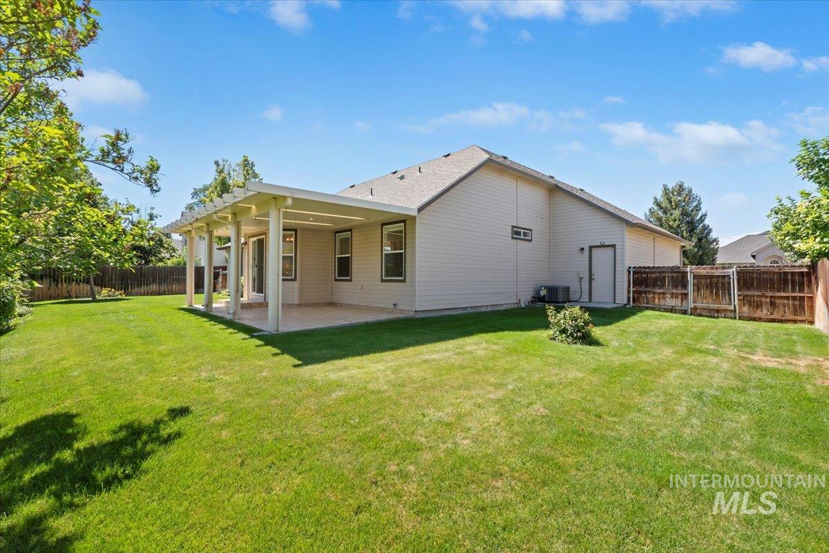 Back of house with a fenced backyard and a patio area