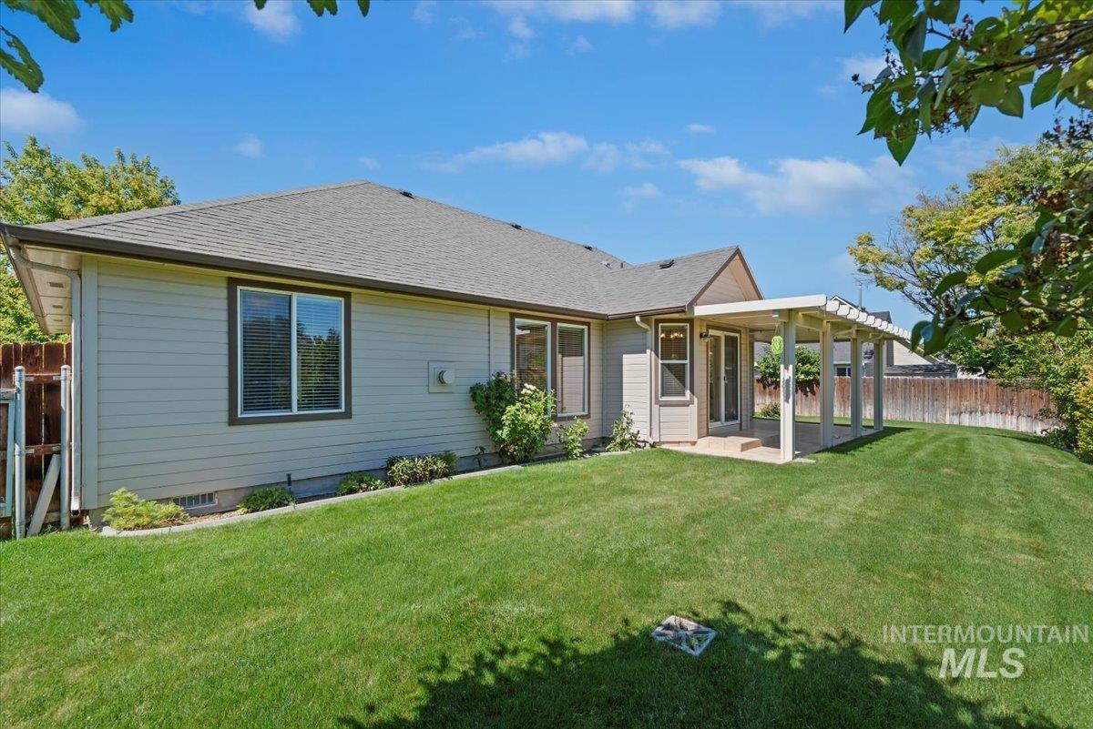 Rear view of house with a patio area and a shingled roof