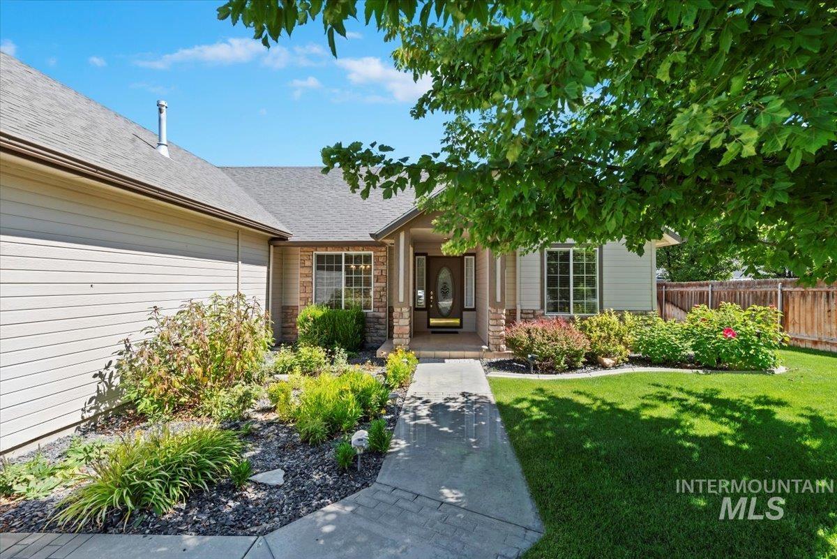 Doorway to property featuring stone siding and a shingled roof
