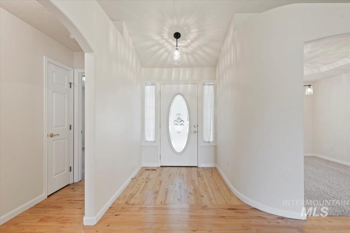 Entrance foyer featuring arched walkways and light wood-type flooring
