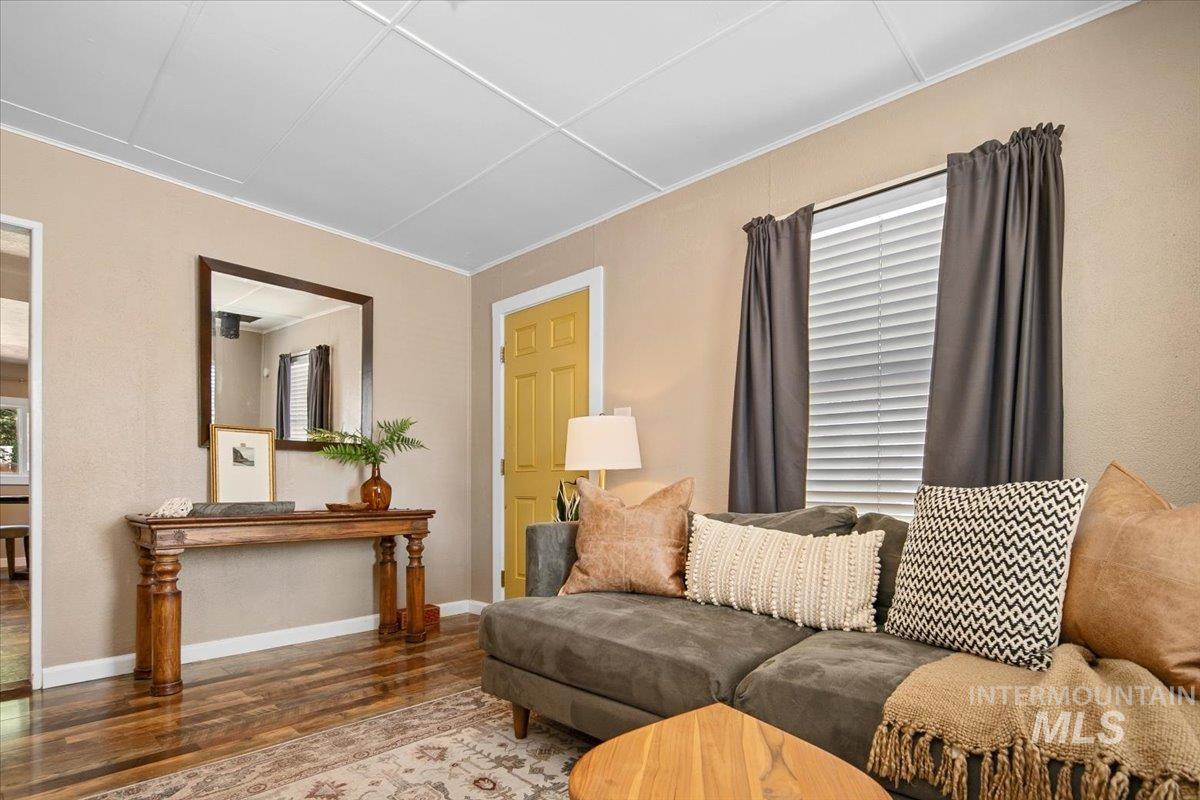 Living room with wood finished floors and ornamental molding