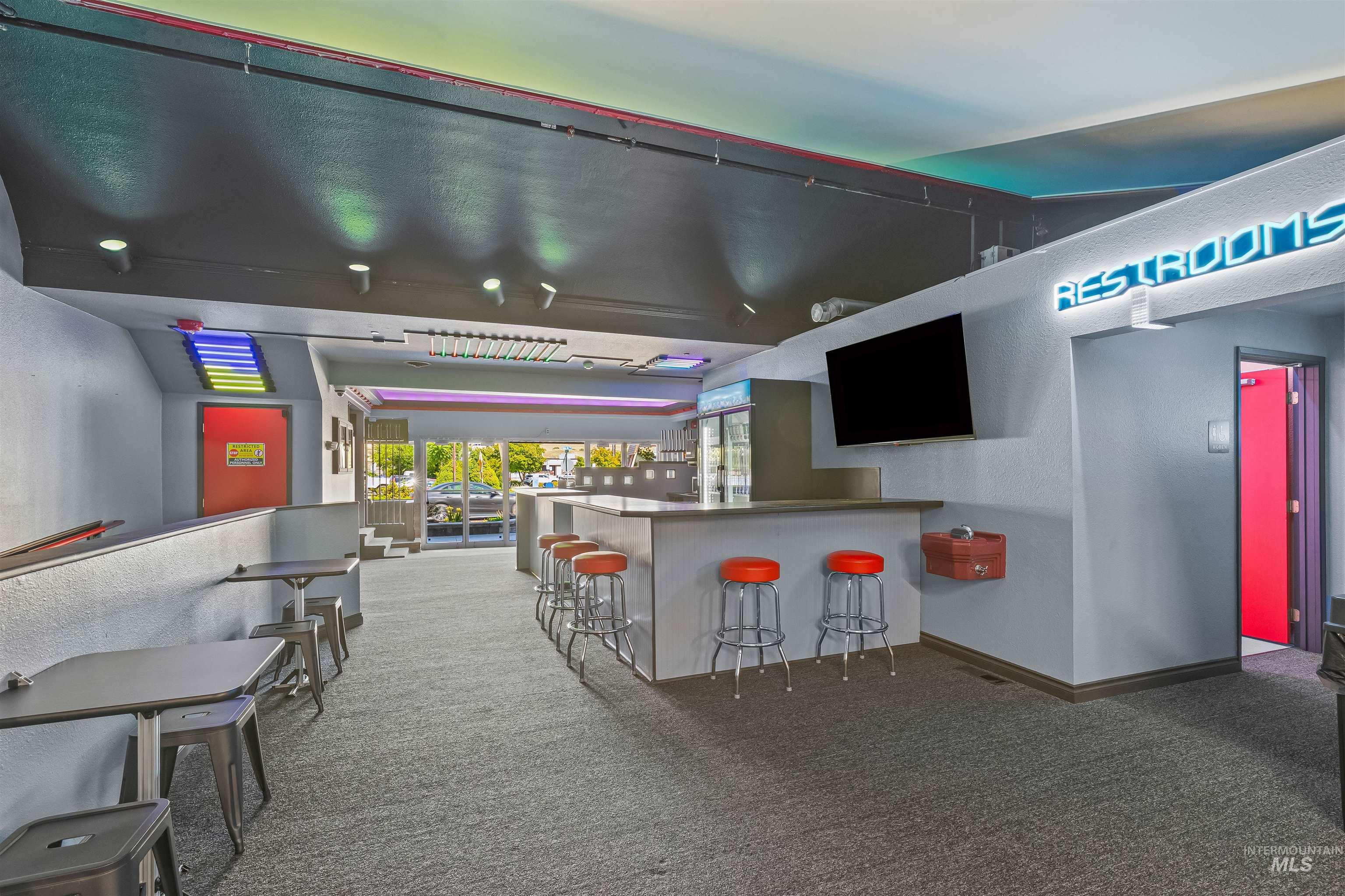 Indoor dry bar with light colored carpet and a textured wall