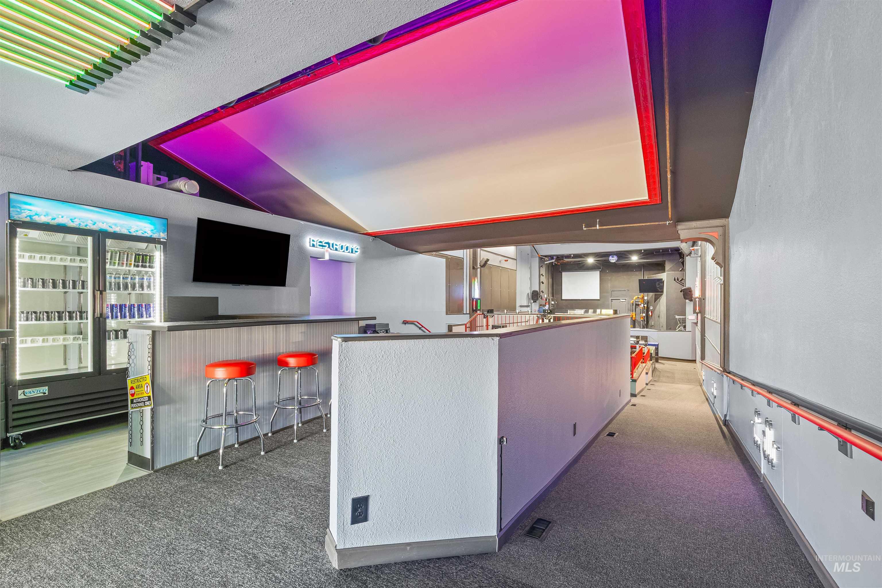 Bar area featuring dark carpet and vaulted ceiling