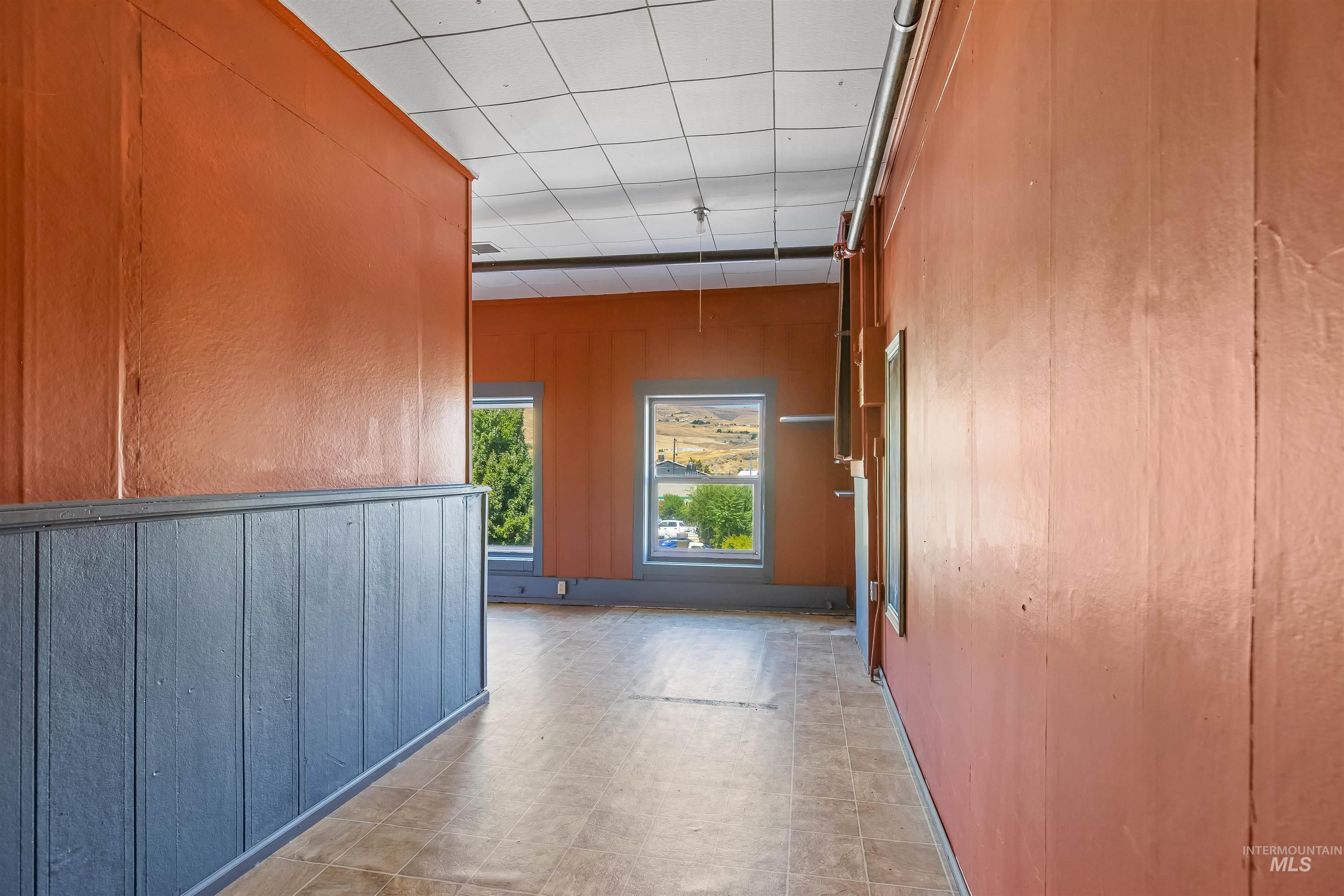 Corridor featuring a drop ceiling and light flooring