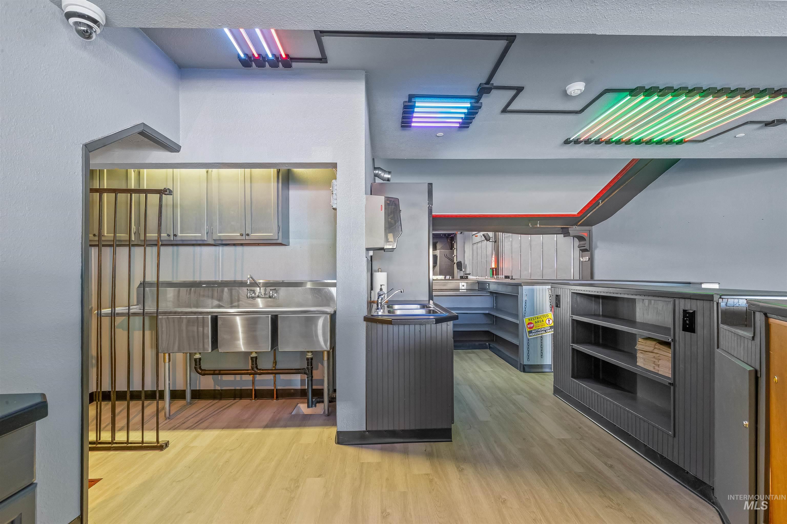 Kitchen with light wood-type flooring, open shelves, and dark countertops