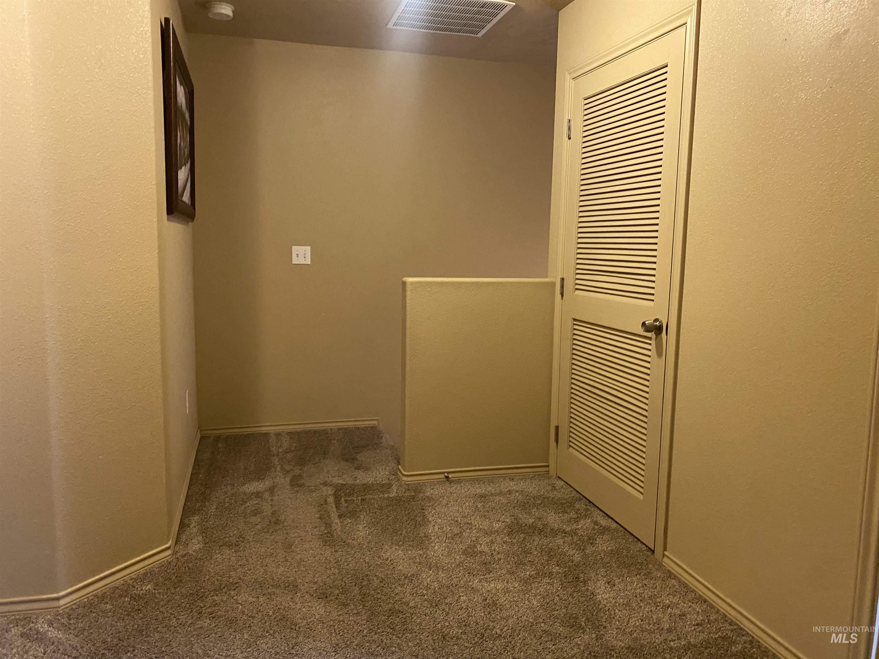 Corridor with carpet floors and a textured wall