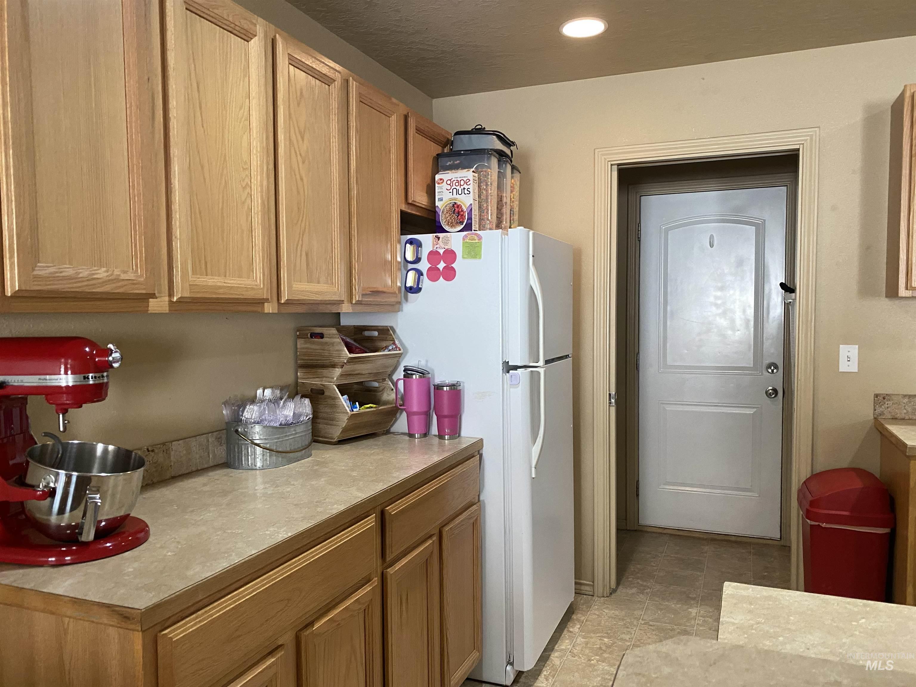 Kitchen featuring light countertops, freestanding refrigerator, and recessed lighting