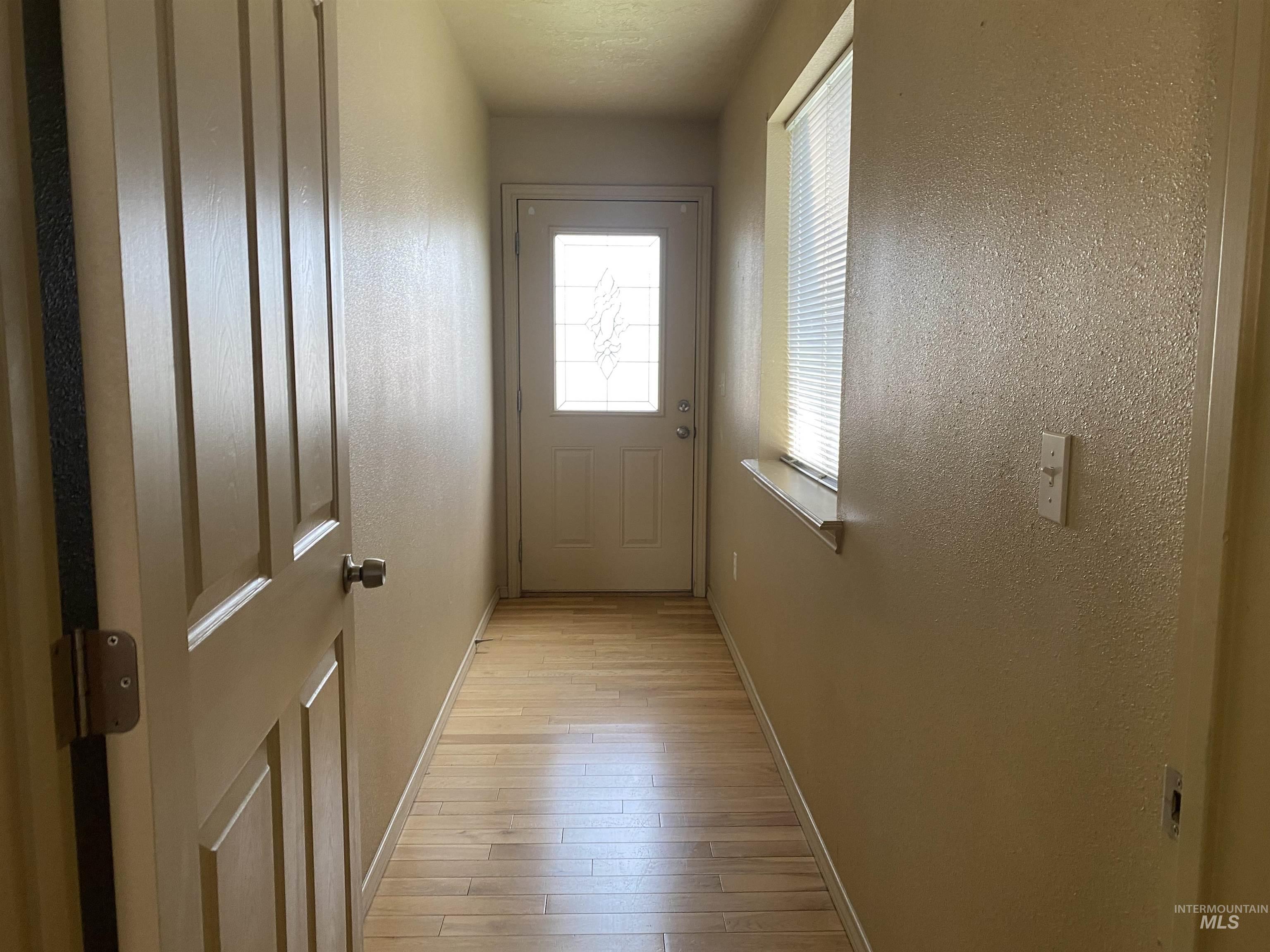 Entryway with wood finished floors and a textured wall