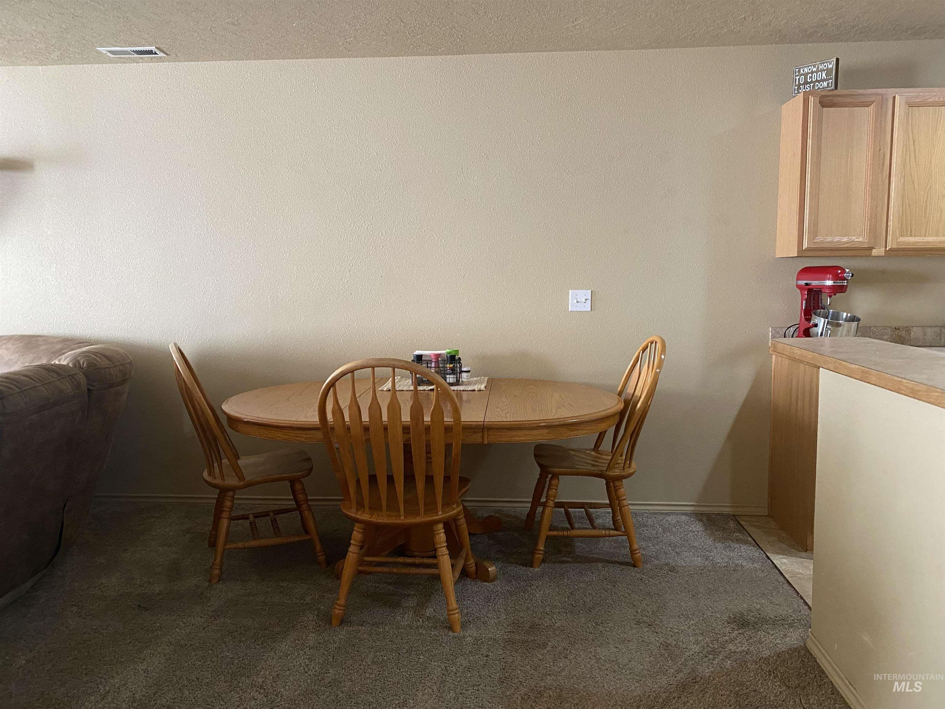 Dining room with dark carpet and a textured ceiling