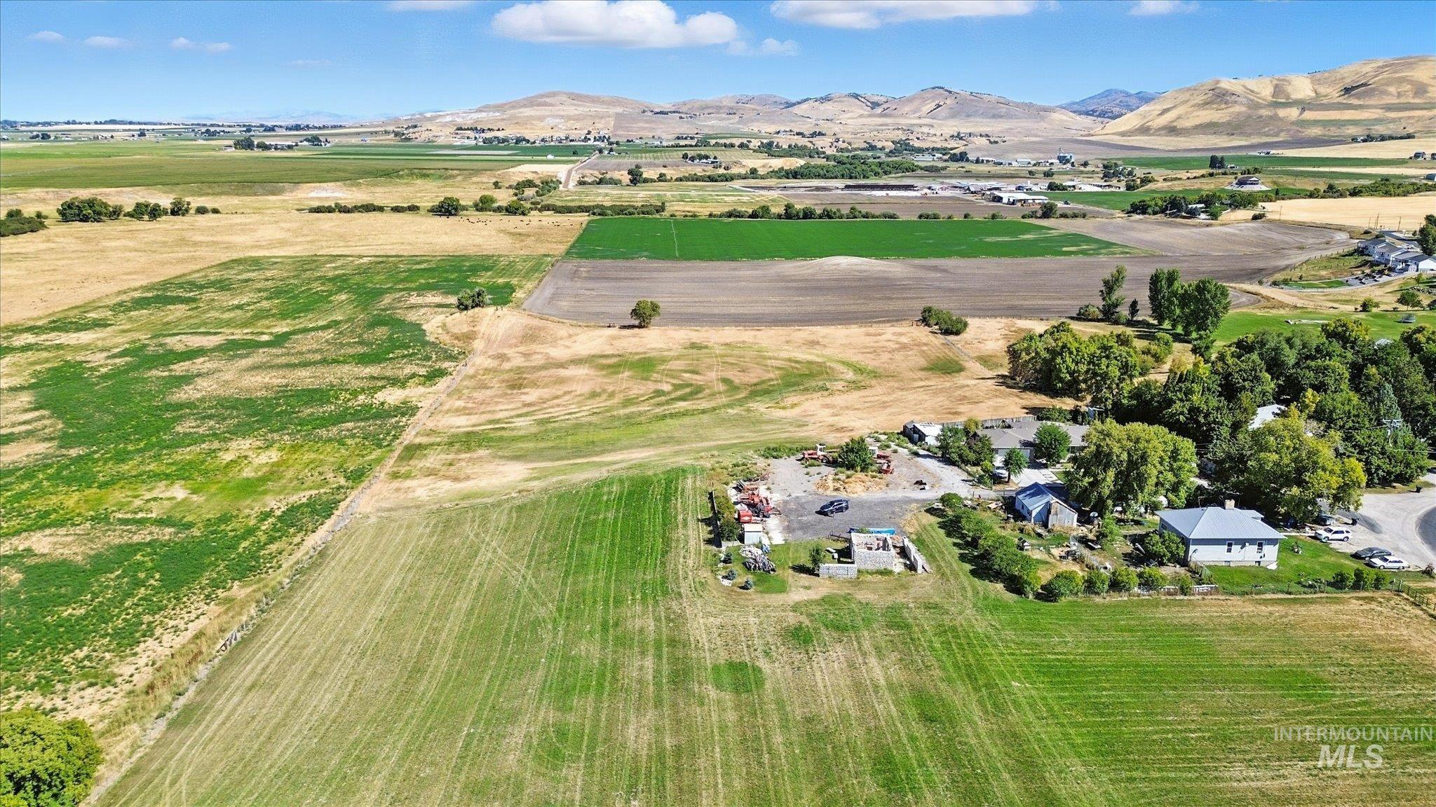 Aerial view of property's location featuring a mountainous background, rural landscape, and extensive farmland