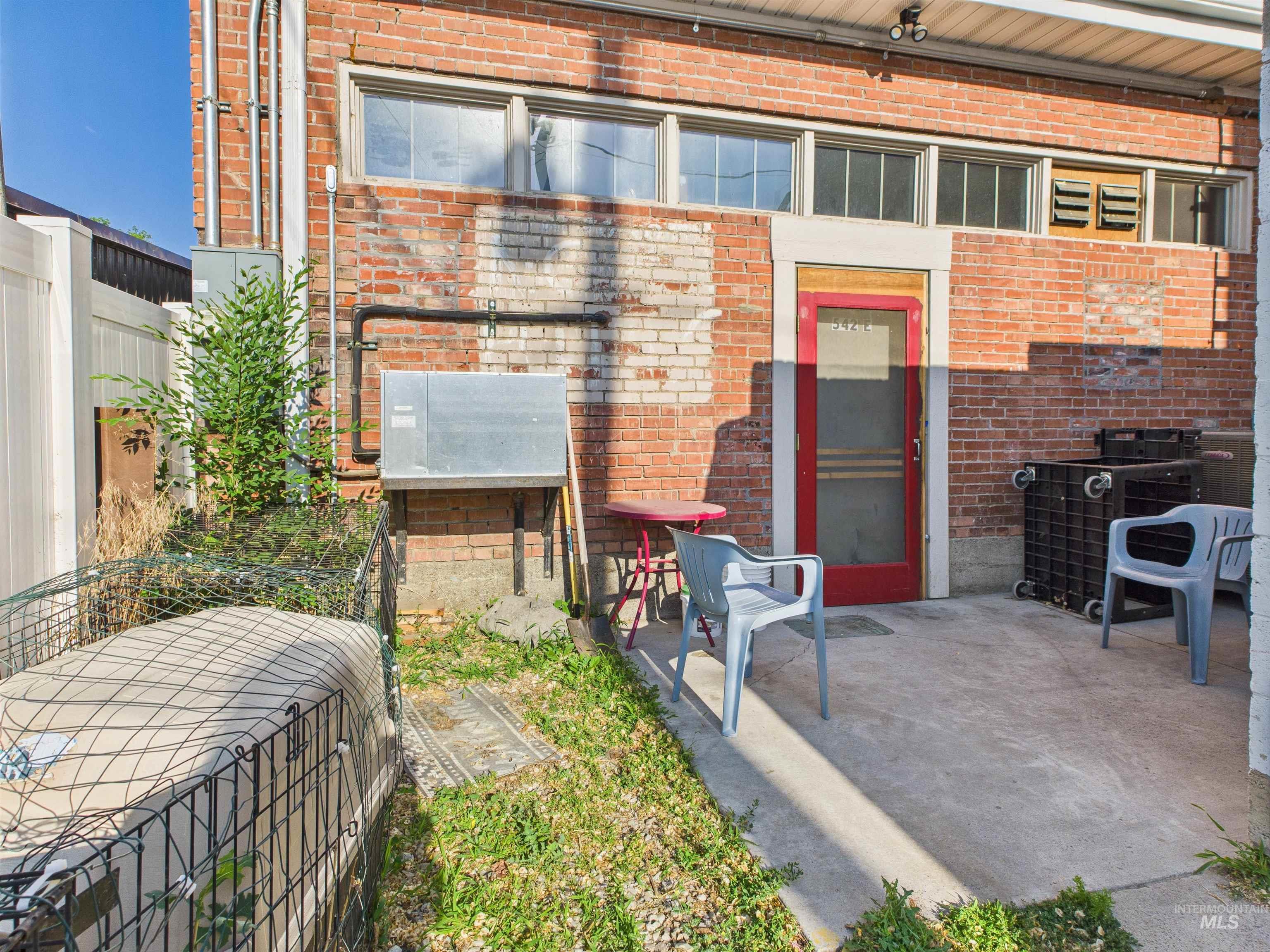 Back of house featuring brick siding and a patio