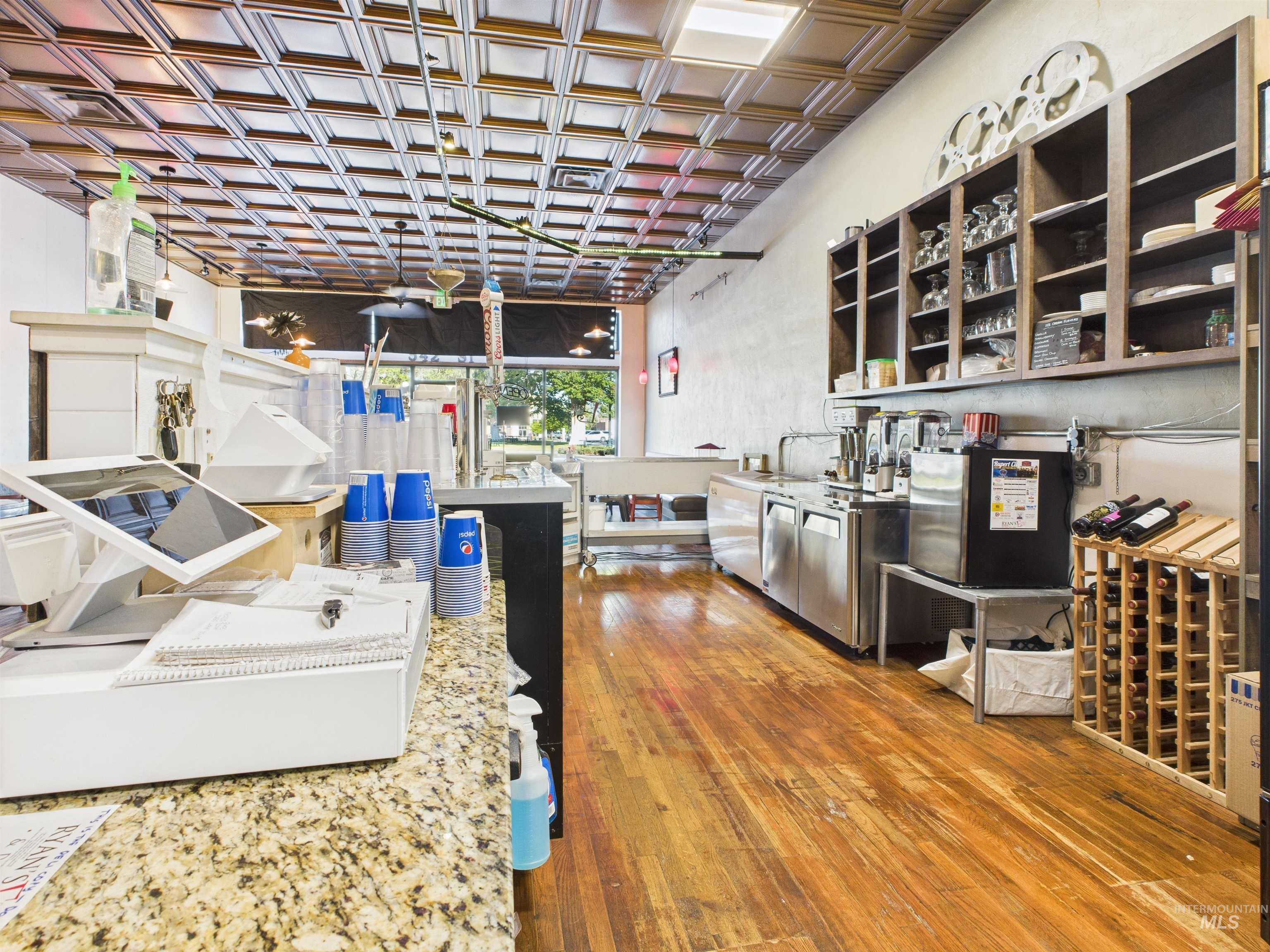 Kitchen with dark wood-type flooring, an ornate ceiling, and open shelves