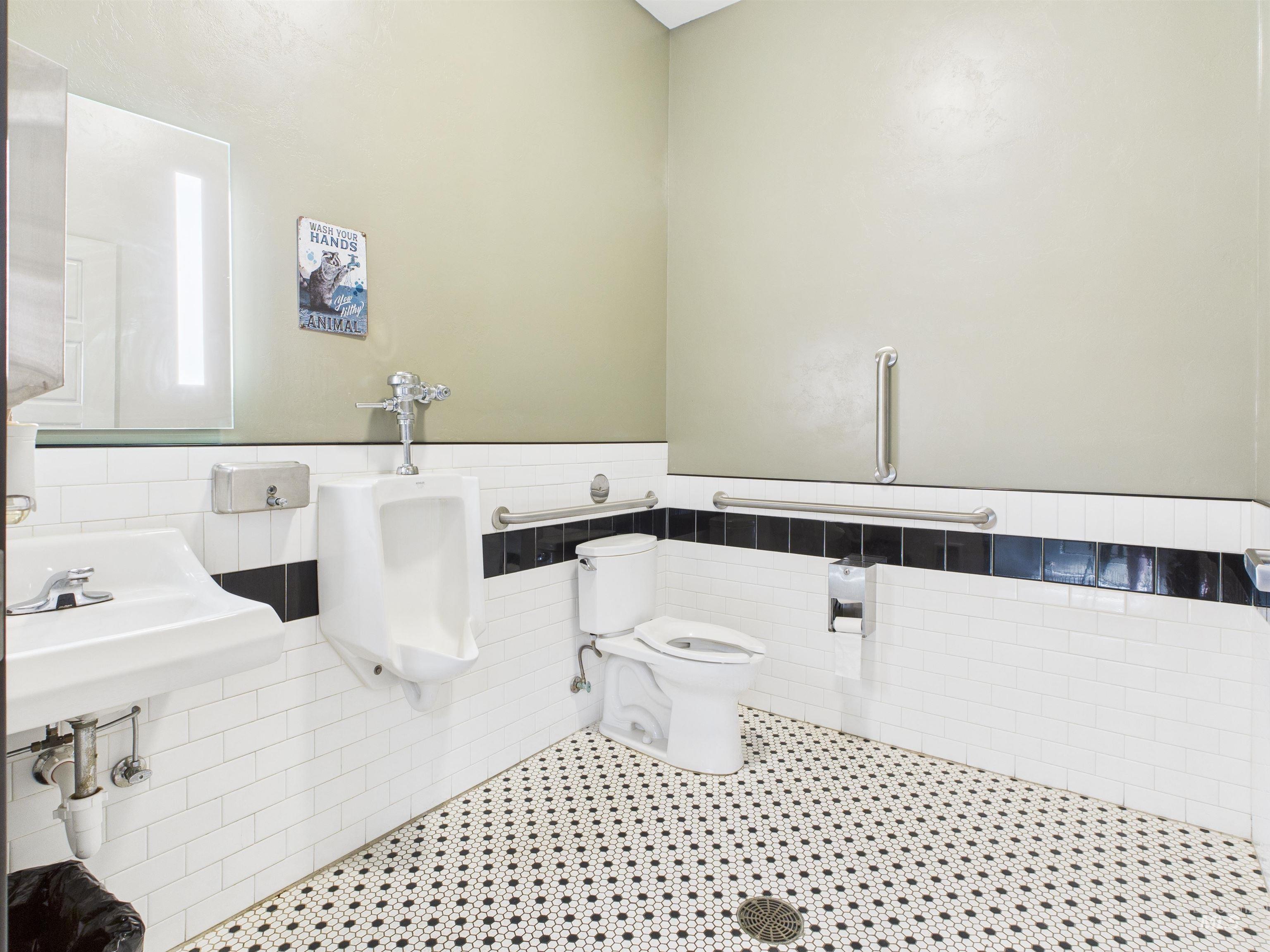 Half bath featuring tile walls, a wainscoted wall, and tile patterned floors