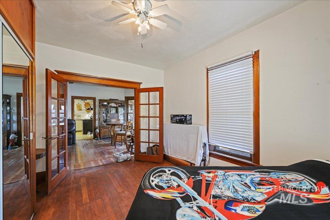 Bedroom with french doors, dark wood-type flooring, and ceiling fan