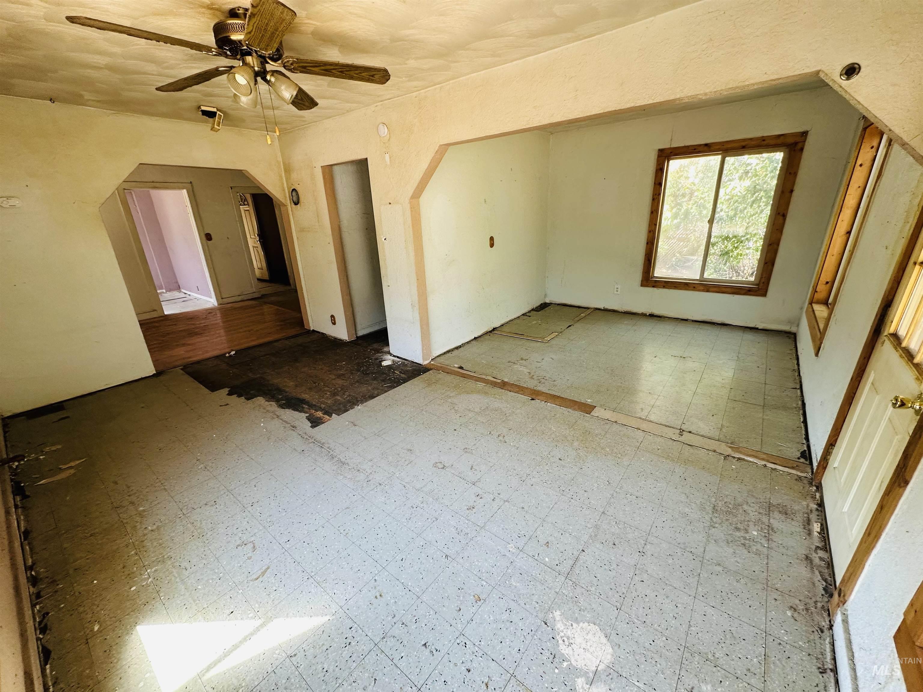 Additional living space with tile patterned floors and ceiling fan