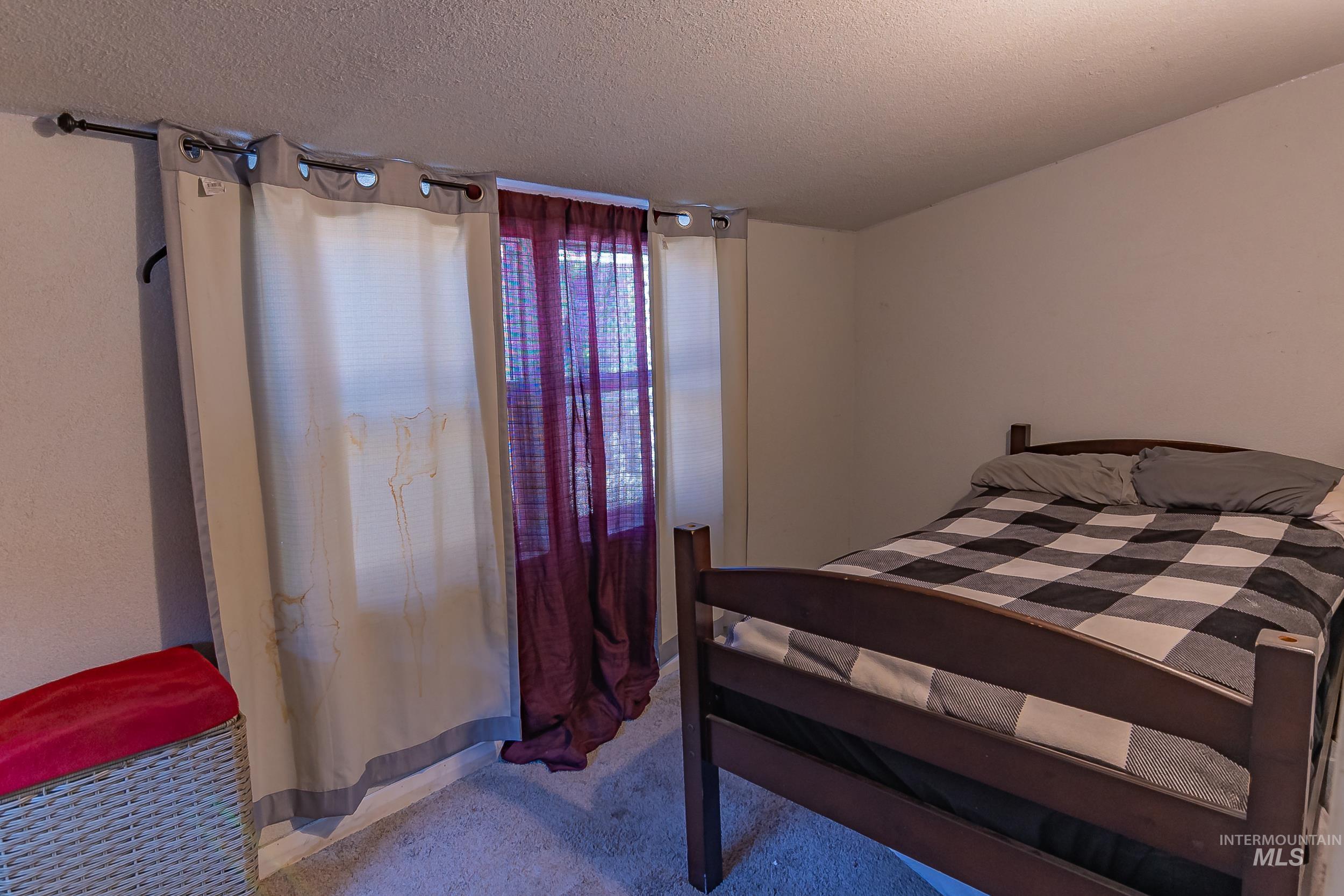 Bedroom with carpet flooring and a textured ceiling