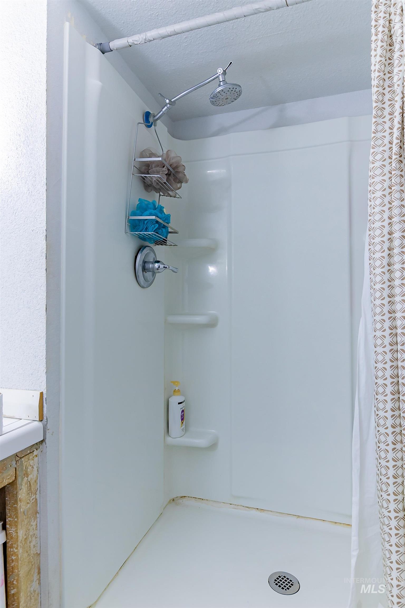 Bathroom featuring a stall shower and a textured ceiling