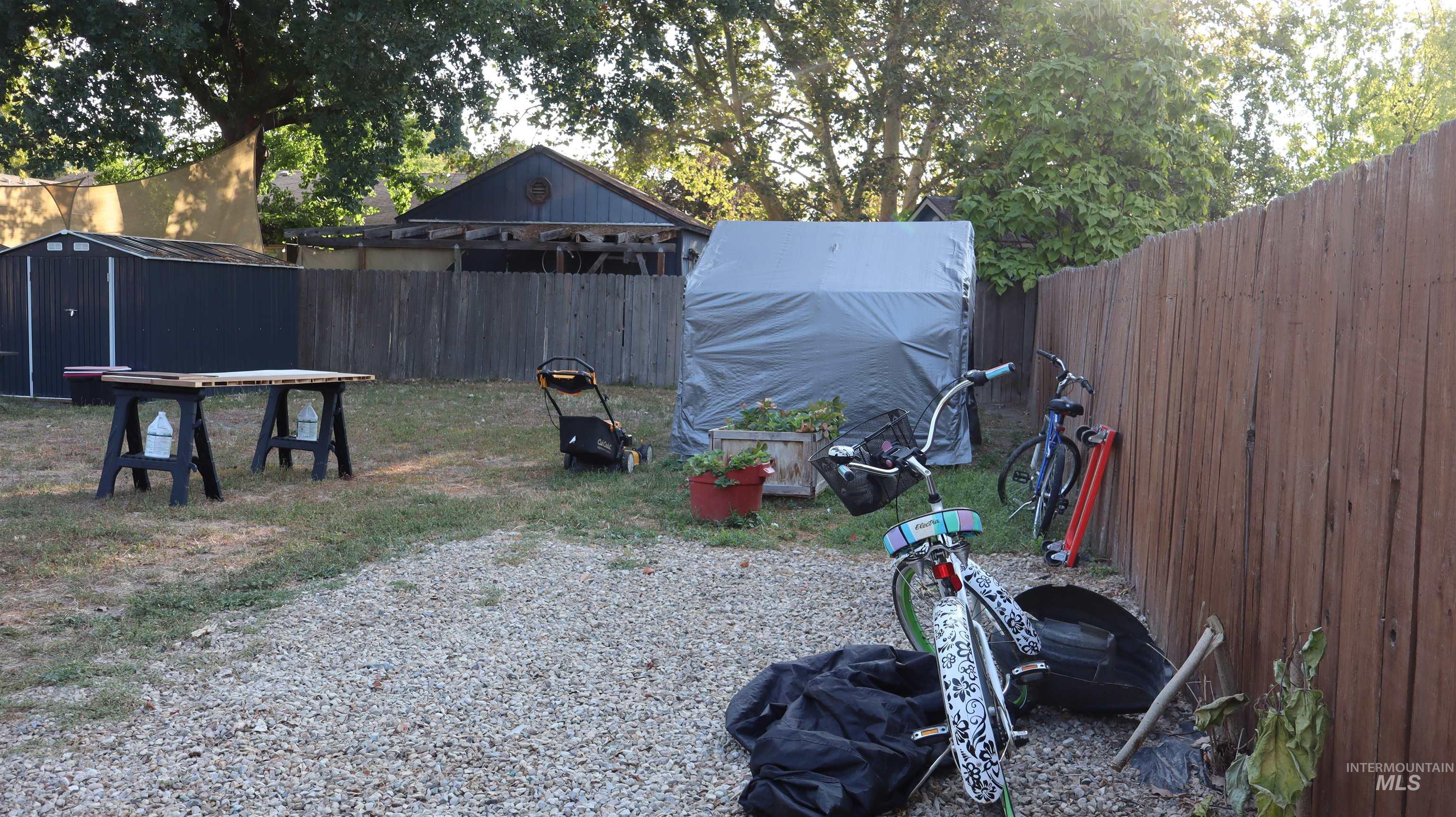Fenced backyard featuring a storage shed
