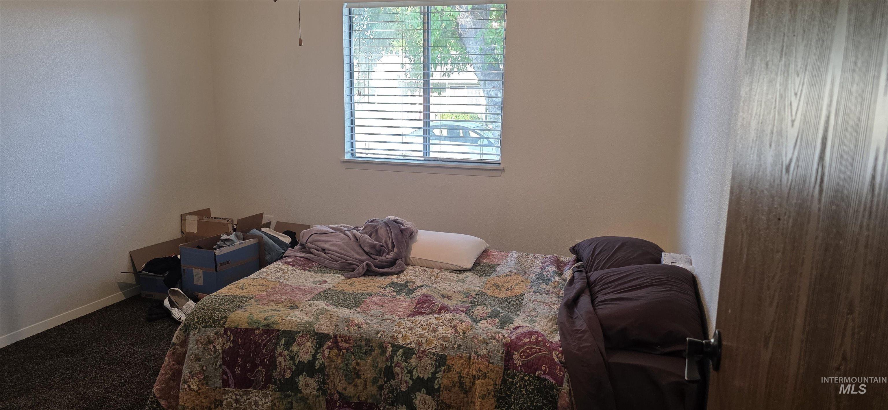 Bedroom with baseboards and dark carpet