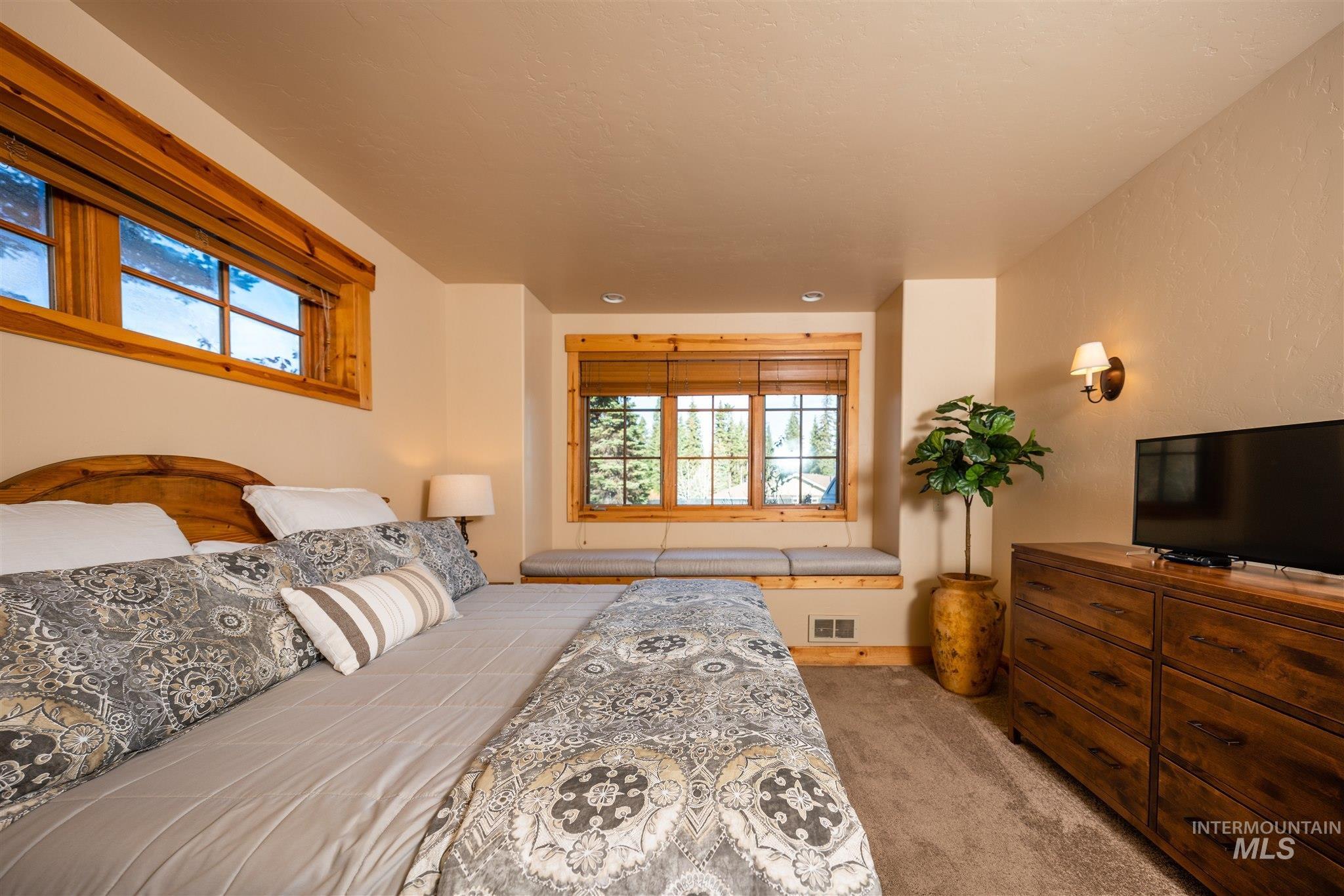 Bedroom featuring light carpet and baseboards
