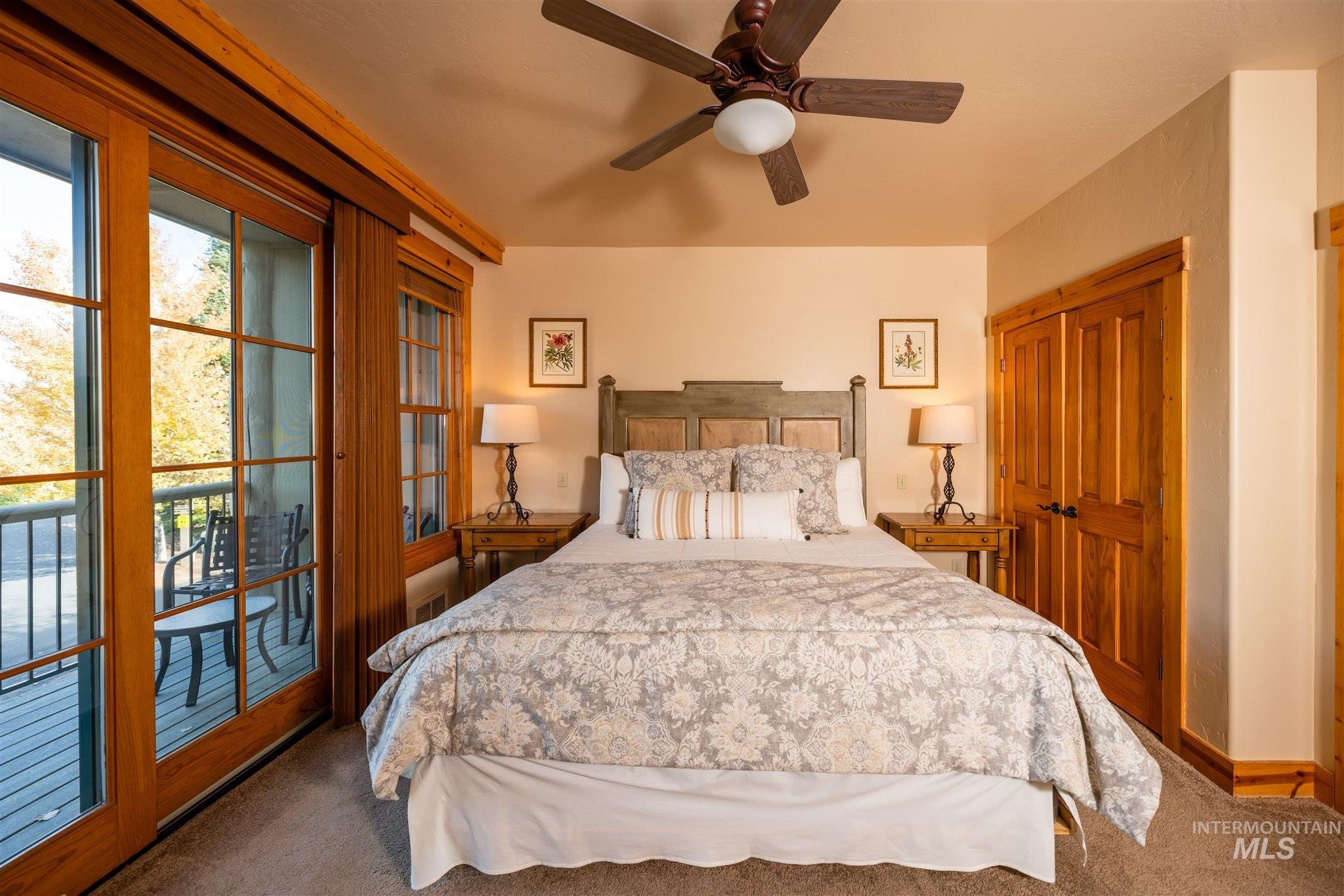 Carpeted bedroom featuring access to outside, ceiling fan, and a closet