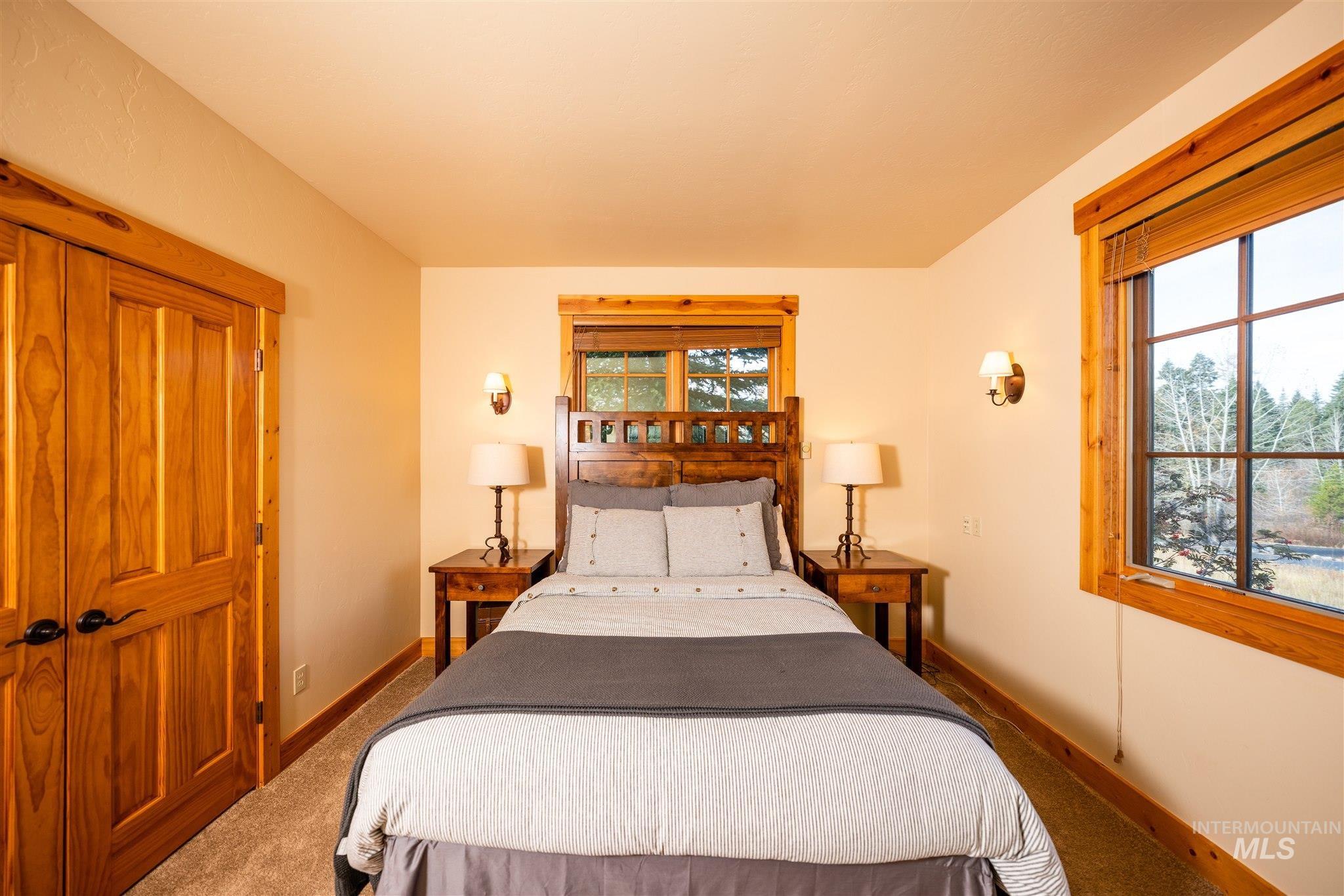 Bedroom featuring multiple windows and carpet flooring