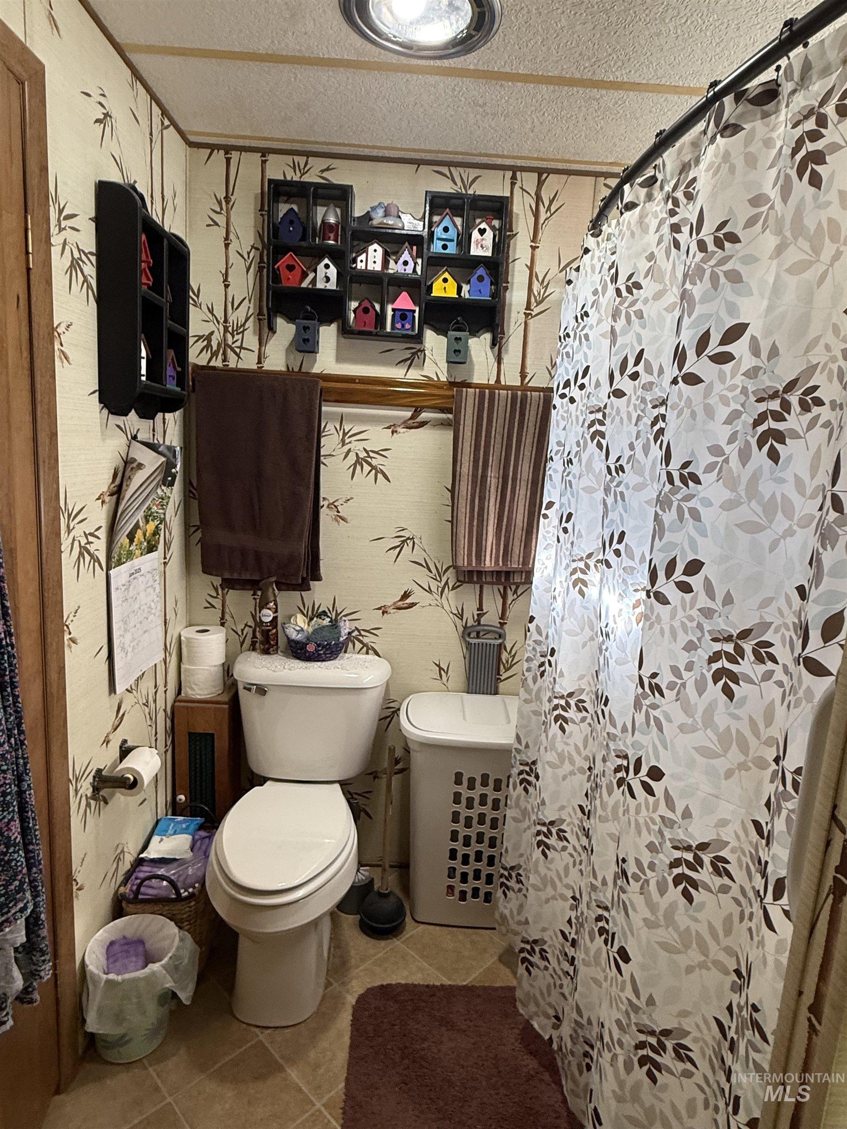 Bathroom with tile patterned flooring, a textured ceiling, and a shower with shower curtain