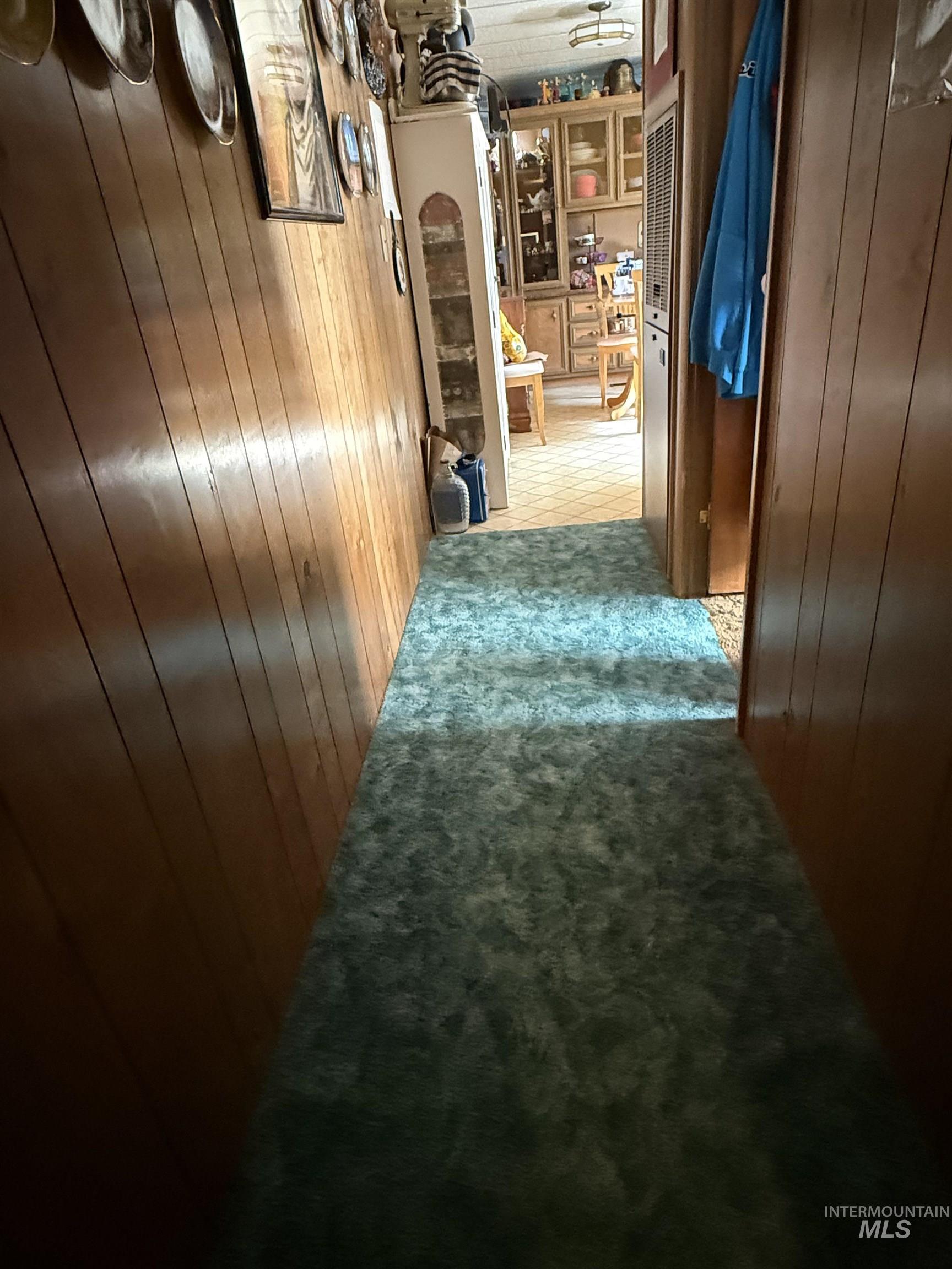 Hall with wood walls and light carpet