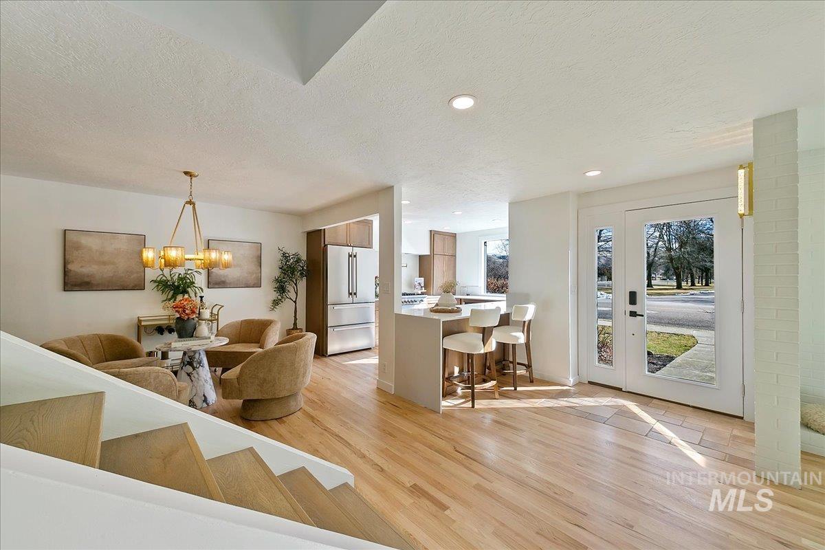 Dining room with a textured ceiling, light wood-style floors, recessed lighting, and a chandelier