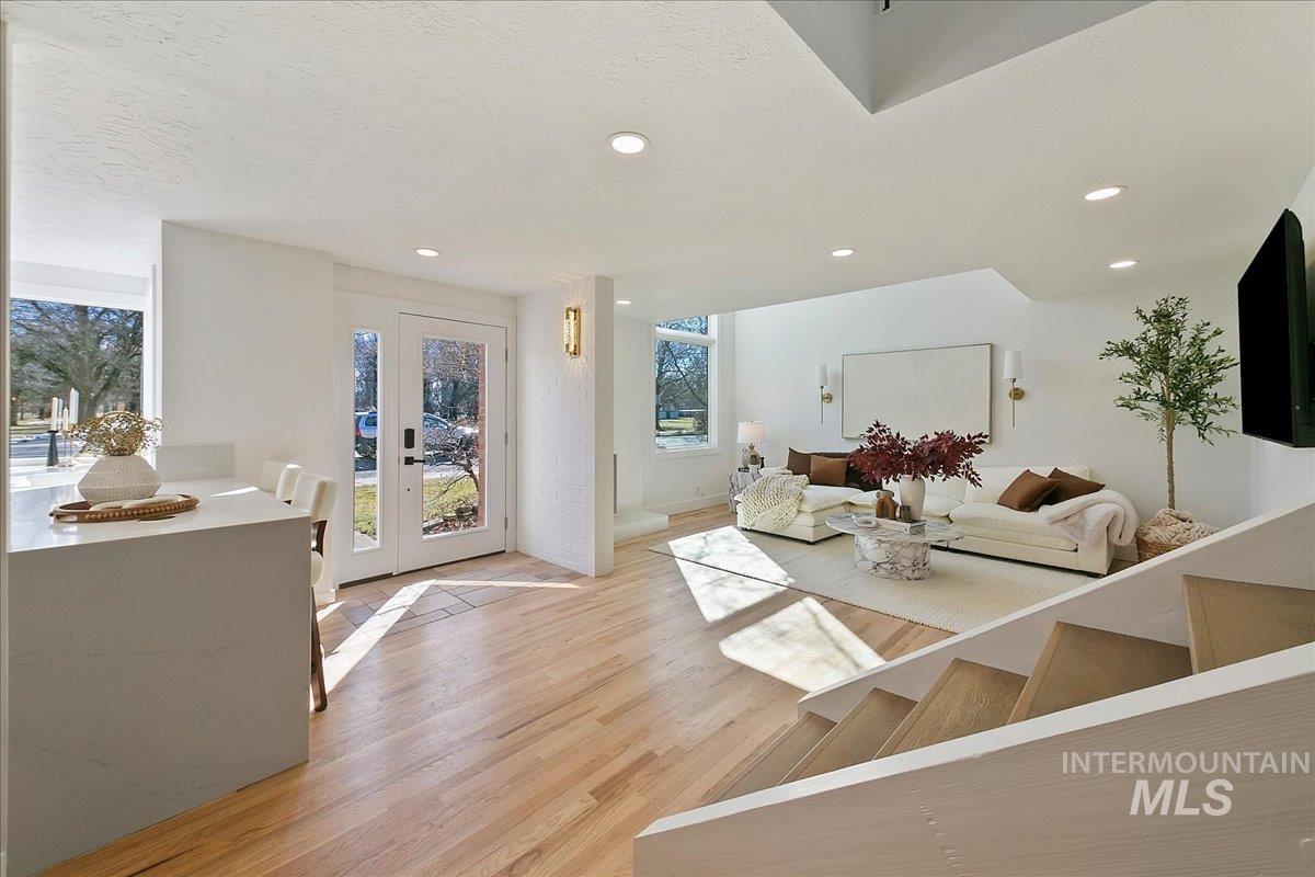Living room with light wood finished floors, recessed lighting, and a textured ceiling