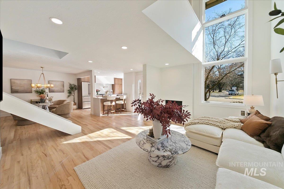 Living area featuring light wood-style floors, recessed lighting, and a chandelier