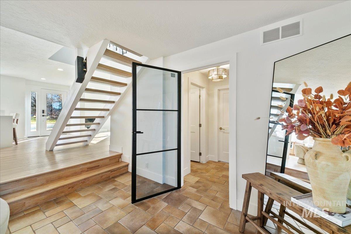 Wine area featuring a textured ceiling, stone tile floors, and french doors