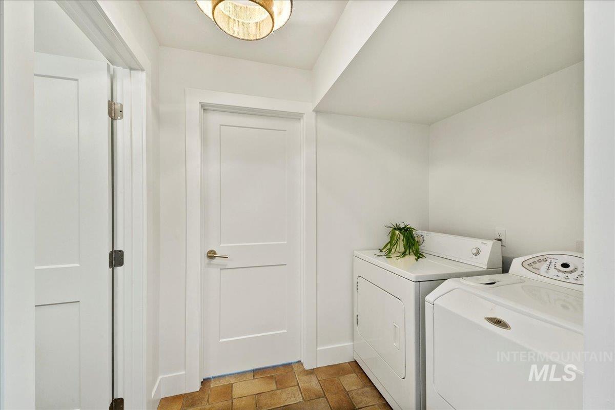 Laundry room featuring washing machine and dryer and baseboards