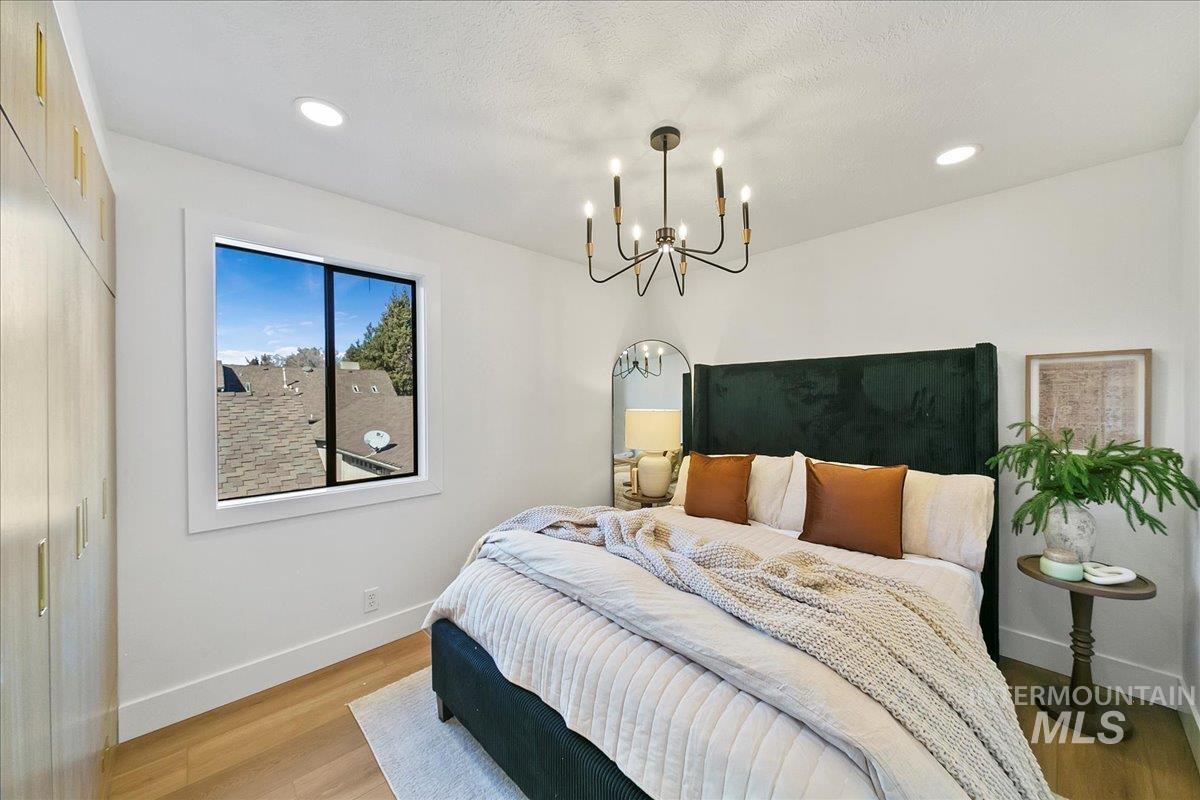 Bedroom featuring wood finished floors, recessed lighting, a chandelier, and a closet