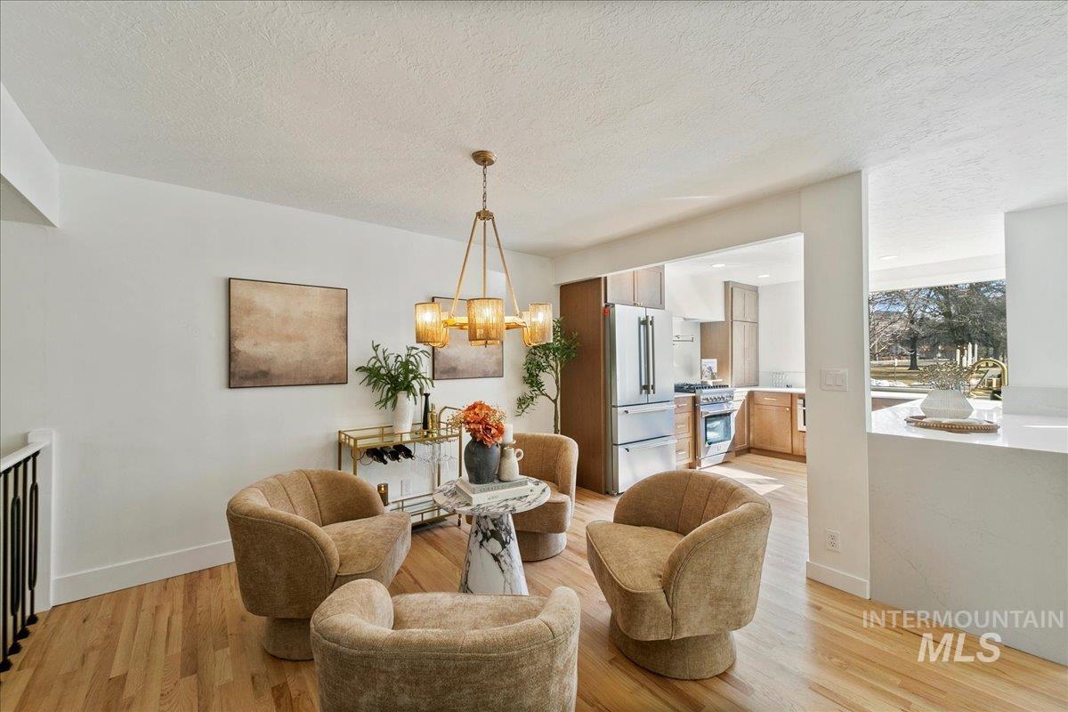Dining space featuring light wood-style floors, a chandelier, and a textured ceiling