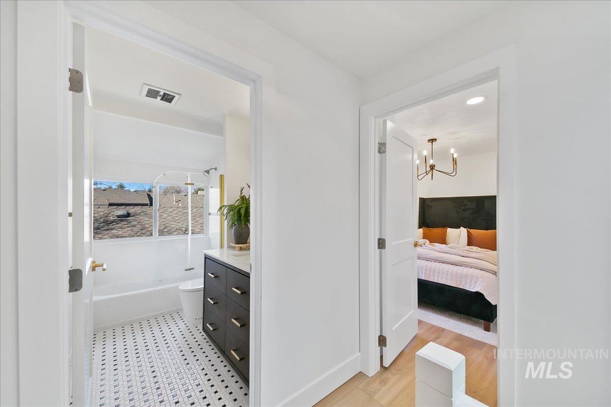 Ensuite bathroom with vanity, shower / tub combination, and recessed lighting