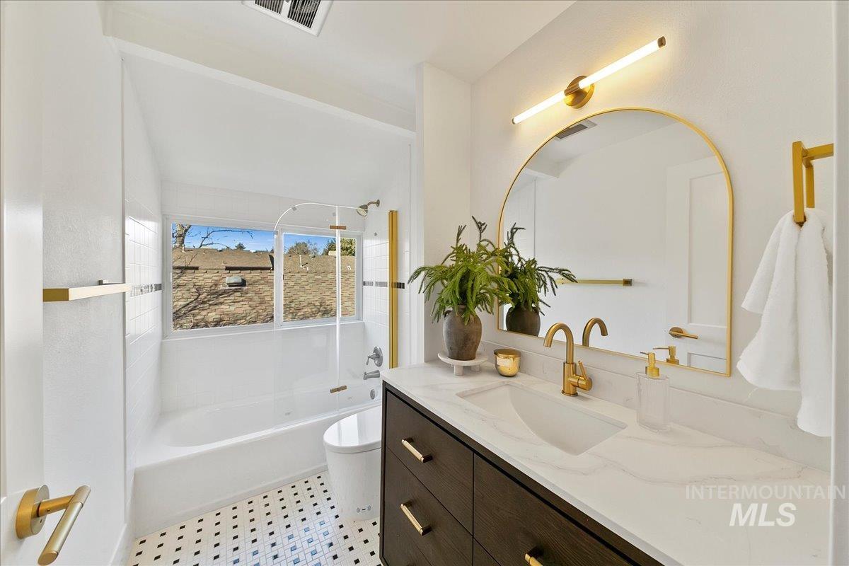 Bathroom with shower / bath combination and vanity