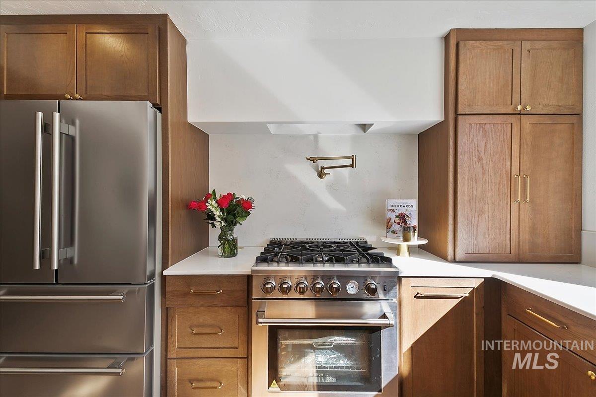 Kitchen with high end appliances and brown cabinetry
