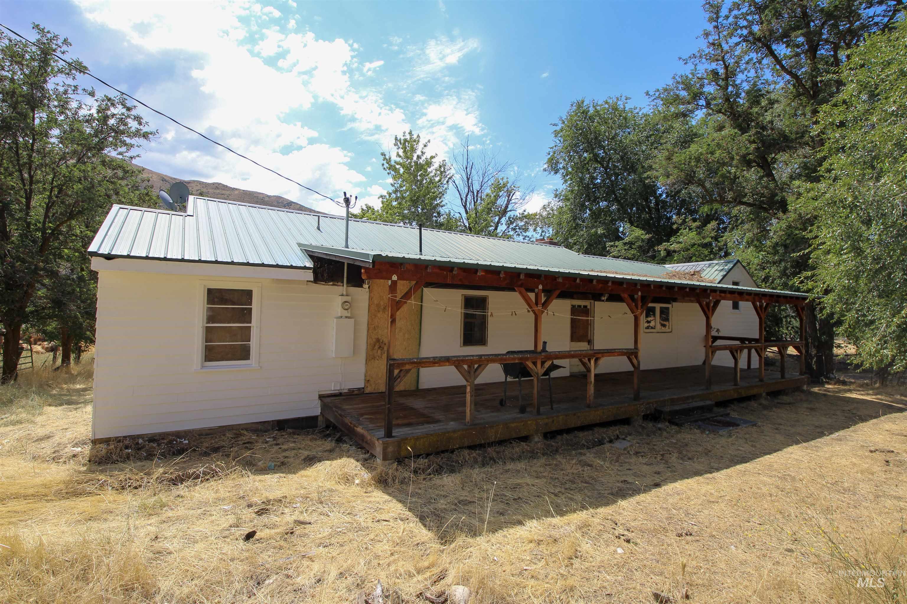 Back of property with a metal roof and a porch