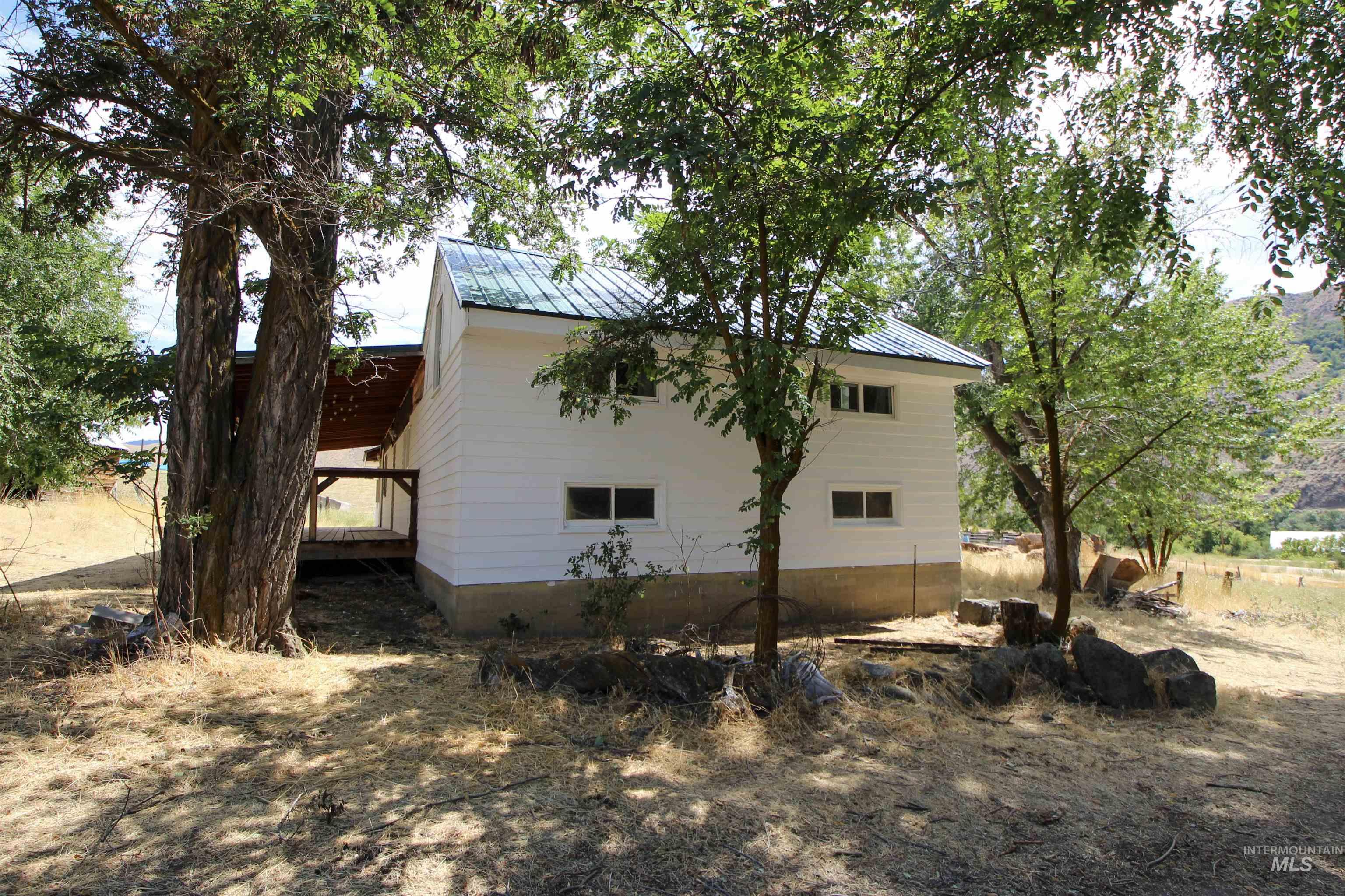 View of side of property featuring a metal roof and a deck