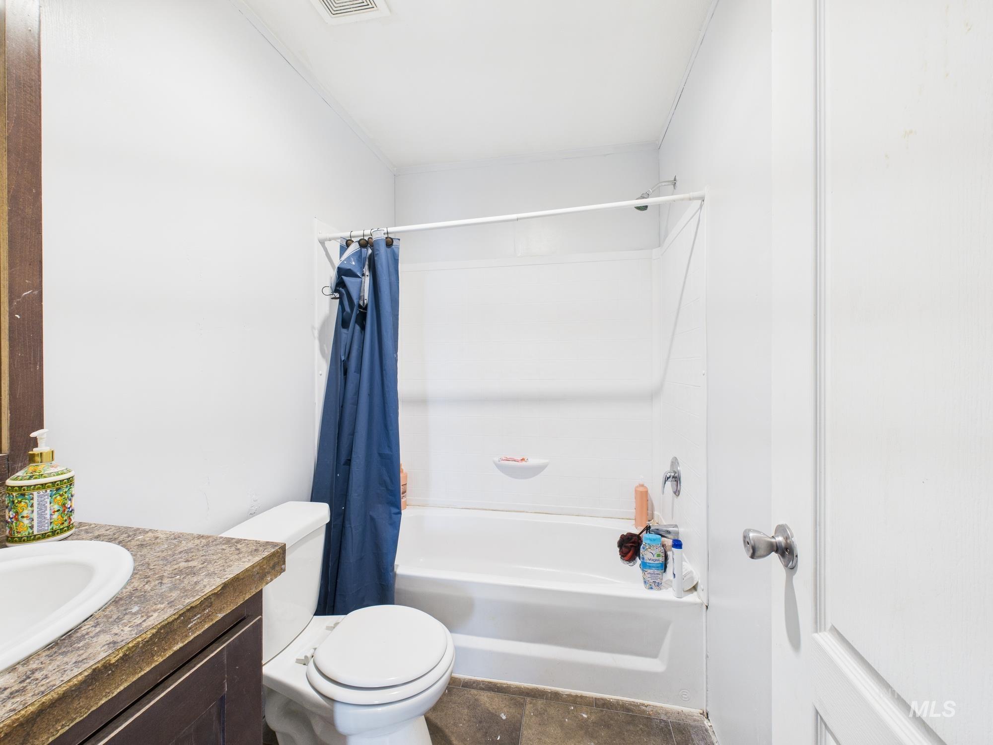 Full bathroom with shower / tub combo with curtain and vanity