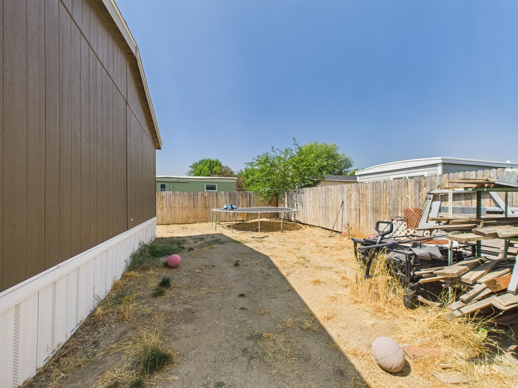 Fenced backyard with a trampoline