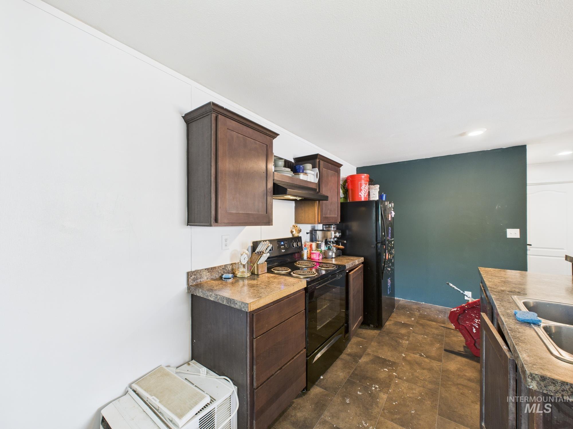 Kitchen featuring dark brown cabinets, black range with electric cooktop, and recessed lighting
