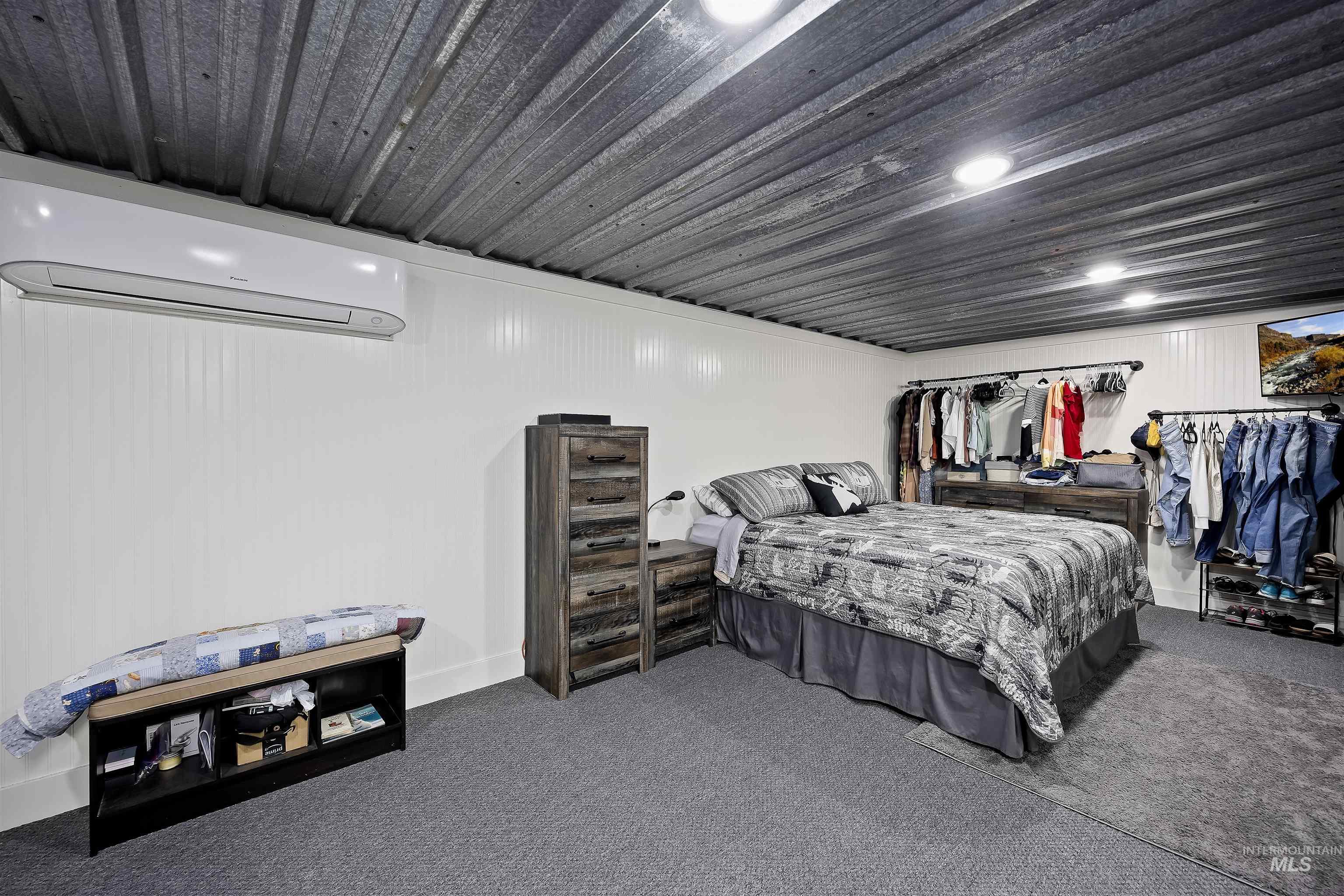 Bedroom with a wall mounted air conditioner and carpet flooring