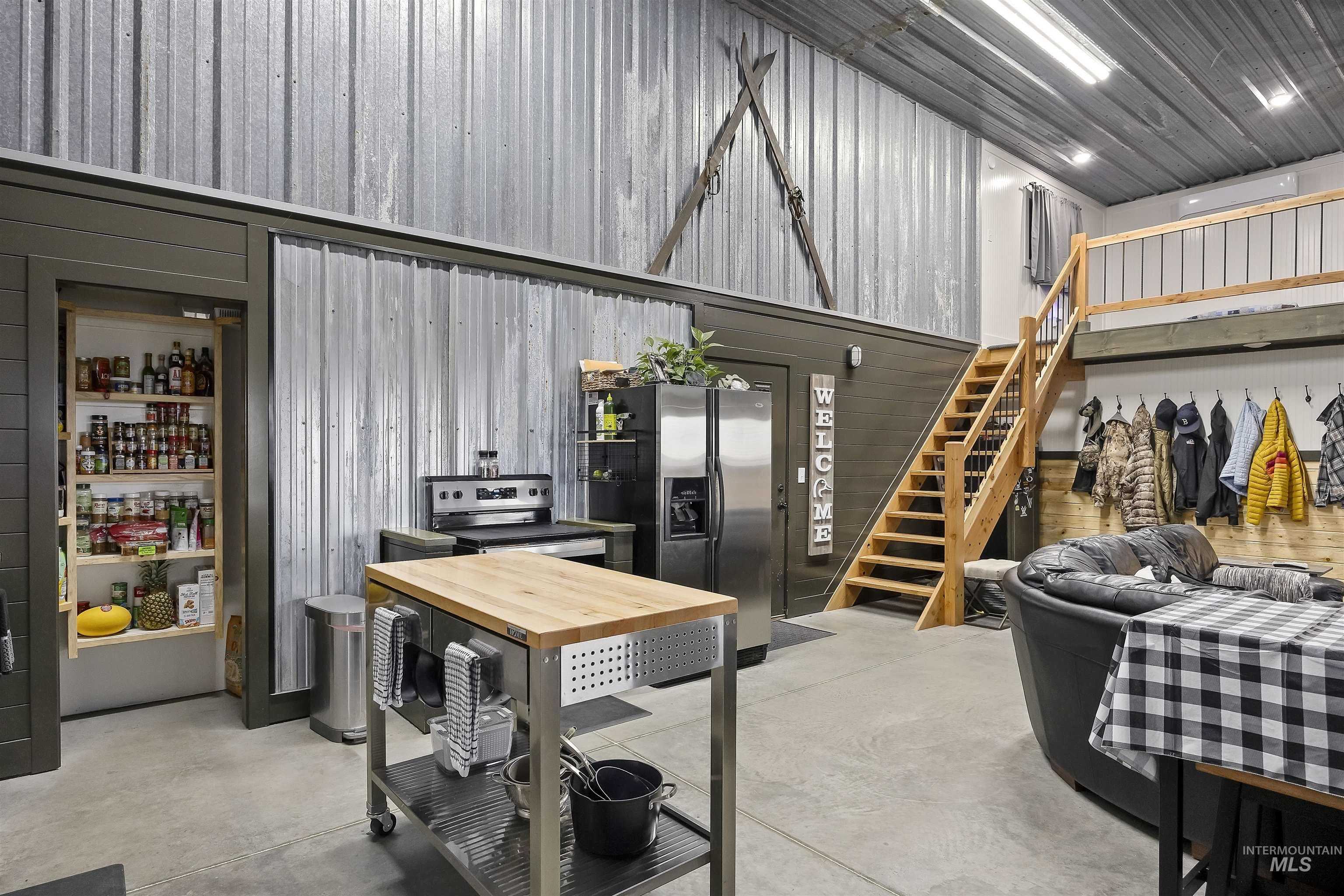 Dining space with stairs, concrete flooring, and metal wall