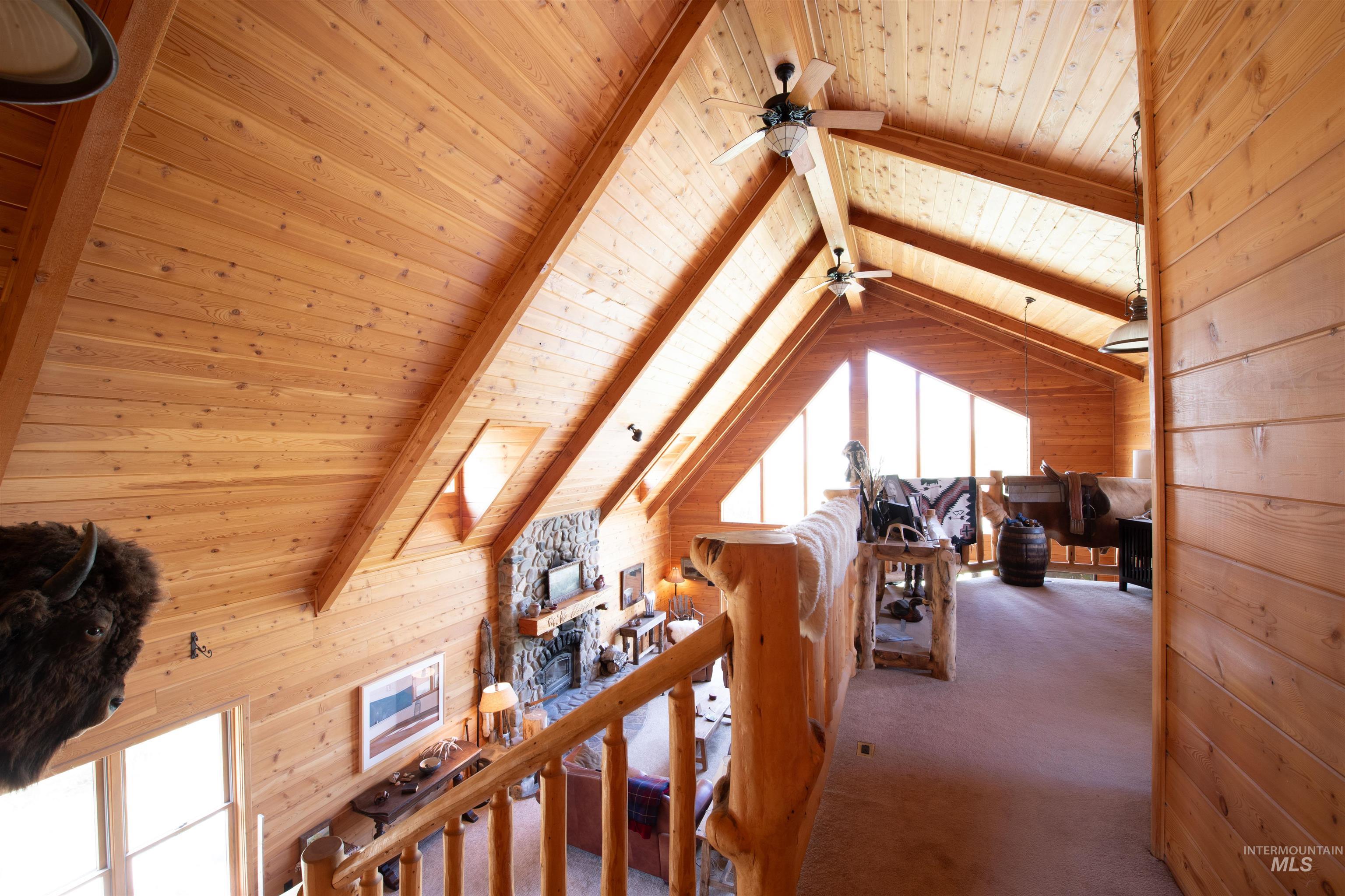 Carpeted bedroom with wood walls, wood ceiling, and a skylight